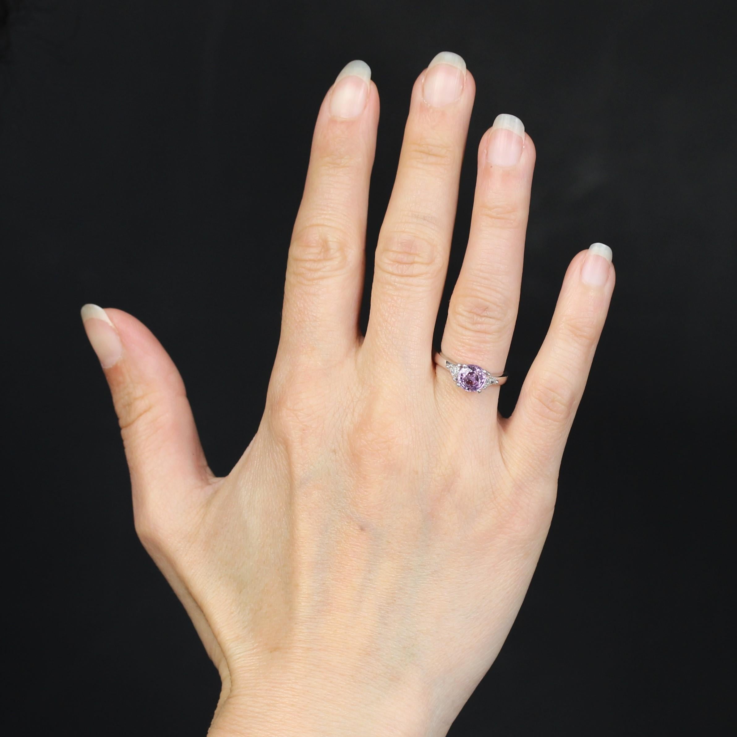 Ring in 18 karat white gold.
A feminine ring in white gold, set at the top with a round pink sapphire with a hint of violet, held in 4 claws. 2 troidia (triangle-cut) diamonds are set in 3 claws on either side of the central gem. The setting's