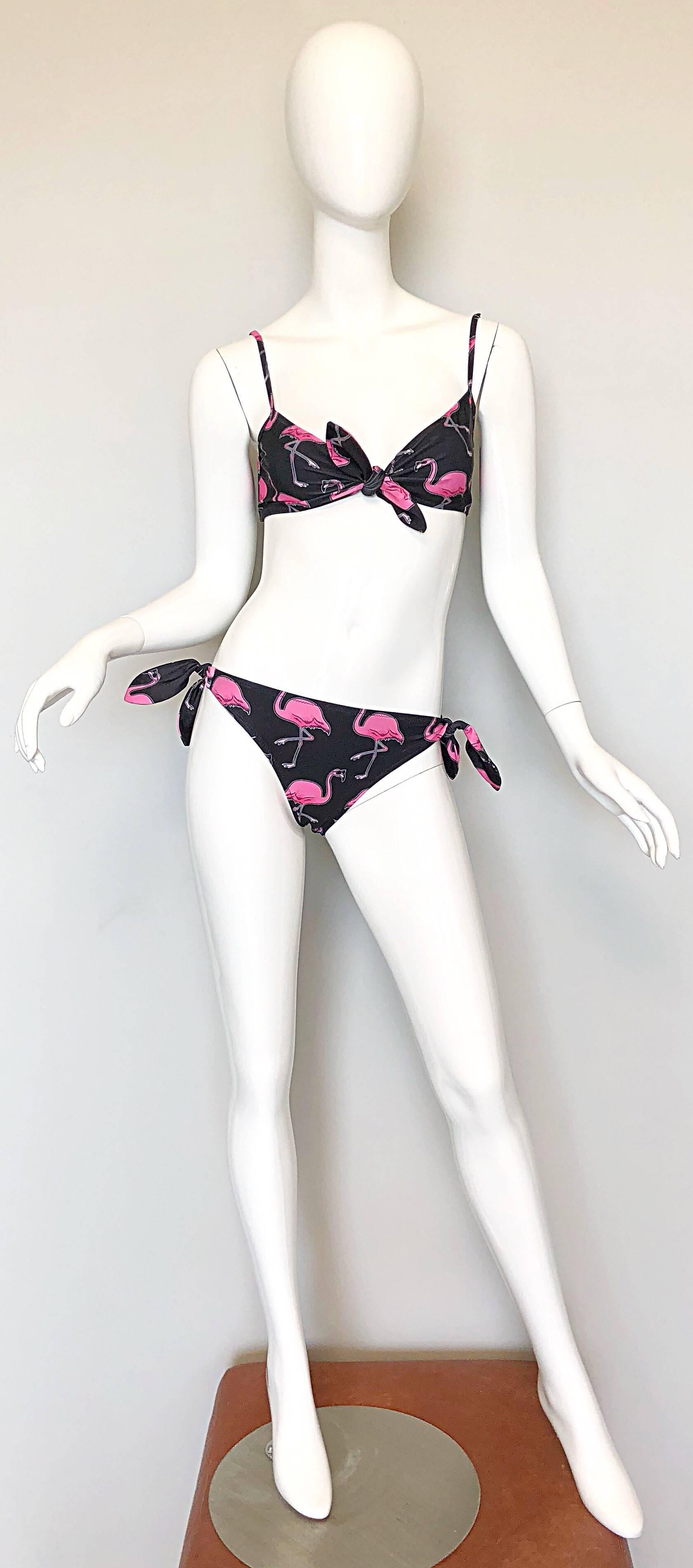 Sexy brand new and sold out MOSCHINO, by JEREMY SCOTT pink and black 'dancing flamingos' novelty bikini. Who says fun can't be sexy? Features printed pink flamingos in sunglasses throughout the top and bottoms. Bikini top features a clasp in the