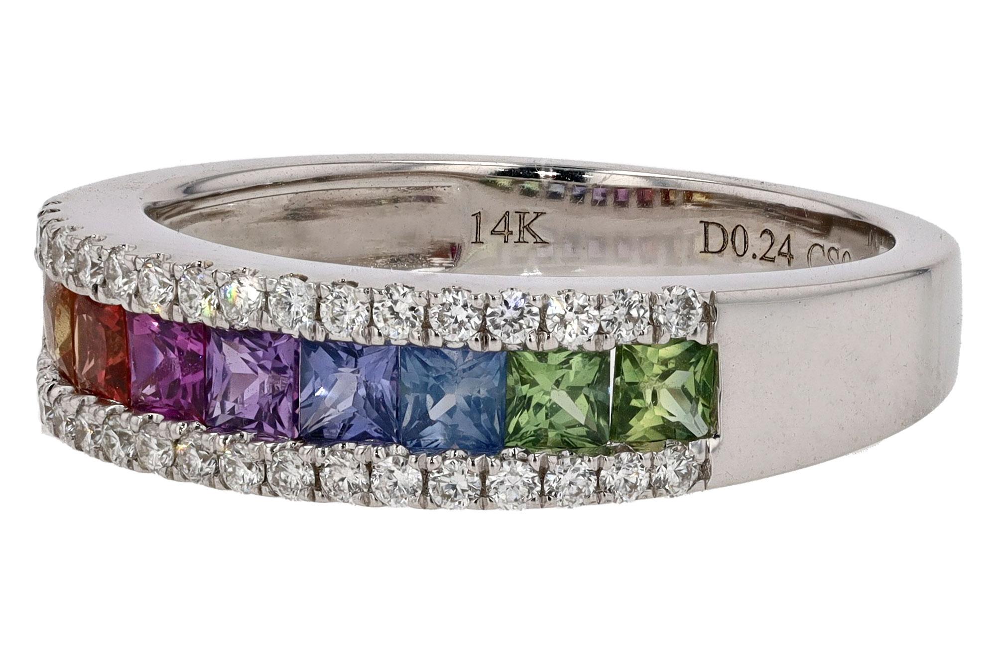 This sleek wedding band features a lovely rainbow of multi colored sapphires ranging from an earthy green that streams fluently to a golden yellow color. The gemstones are fenced with rows of diamonds amongst the gleaming 14k white gold setting.