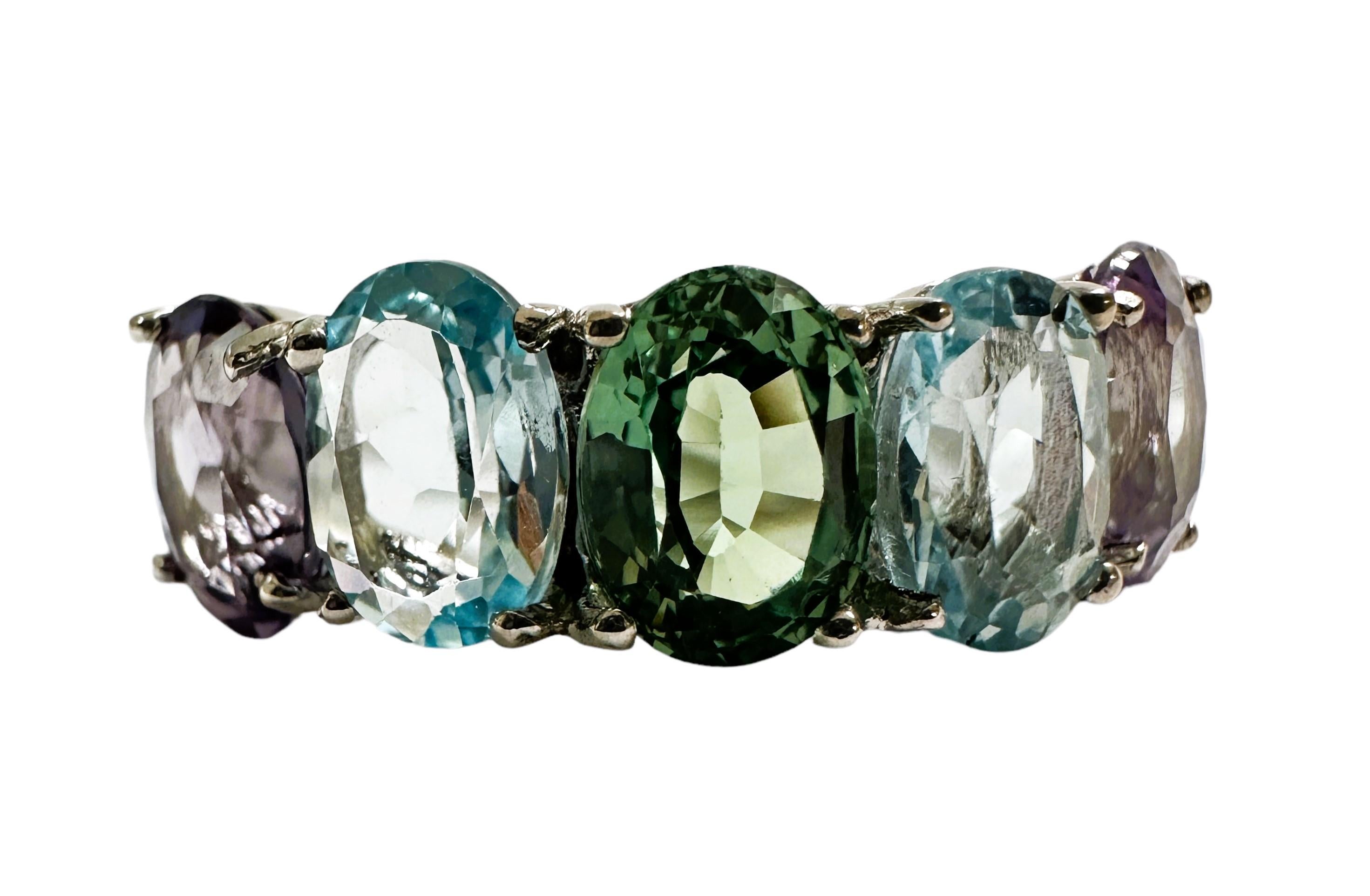 Das ist einfach ein wunderschöner Ring!  Ich liebe alle Farben, die es gibt.  Es ist eine Größe 7.  Die Steine sind 7 x 5 mm groß und haben insgesamt 5,50 Karat. Es gibt einen grünen Stein, einen hell- und dunkelvioletten und einen hell- und
