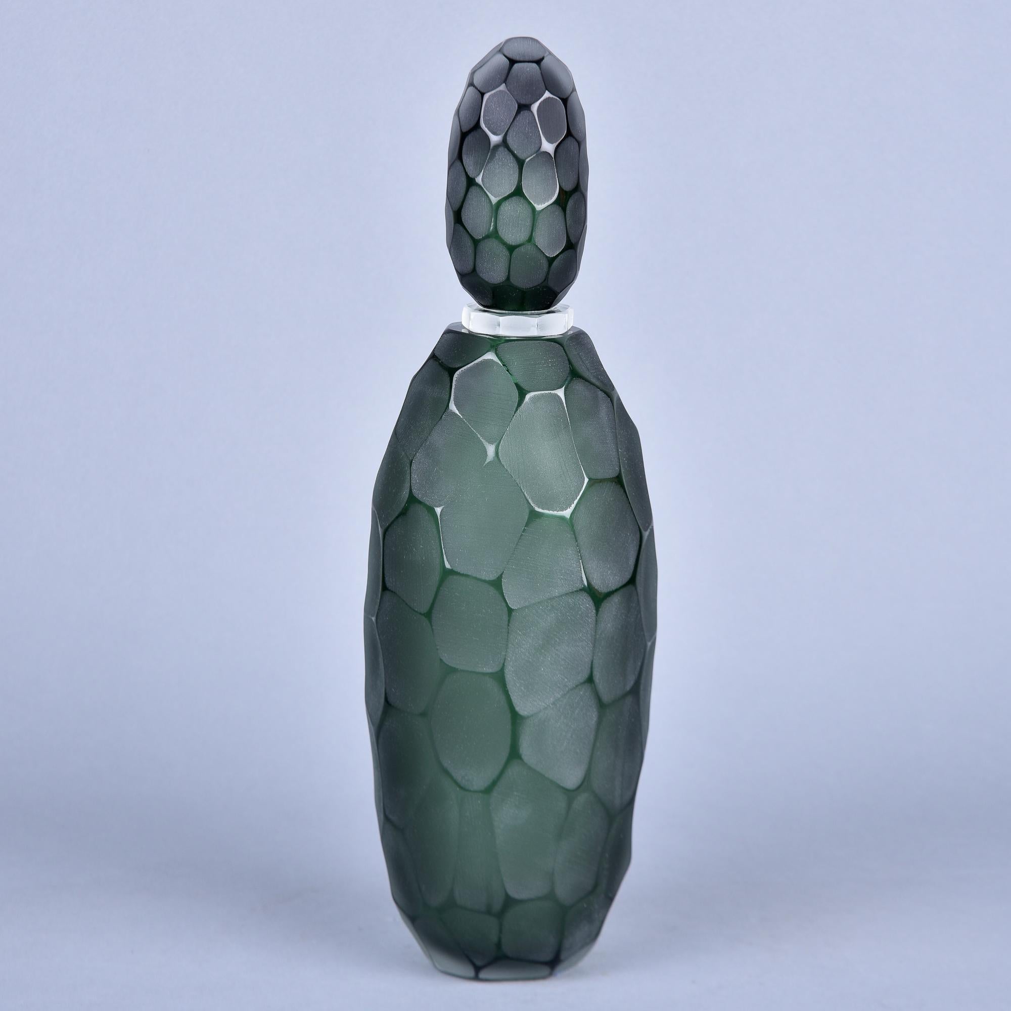 Neuf et fabriqué en Italie par un verrier inconnu de Murano, ce flacon de parfum mesure 18 pouces de haut avec le bouchon et 5,5 pouces de diamètre. Le verre lourd et foncé de couleur vert bouteille présente des détails de surface taillés et polis -