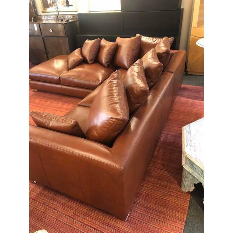 Aleather sectional by Nathan Anthony, custom built in Los Angeles. The folio sofa makes an elegant statement in both modern or contemporary decors, enveloped in polished cognac leather. Featuring trapezoidal-shaped arms, the sectional floats on