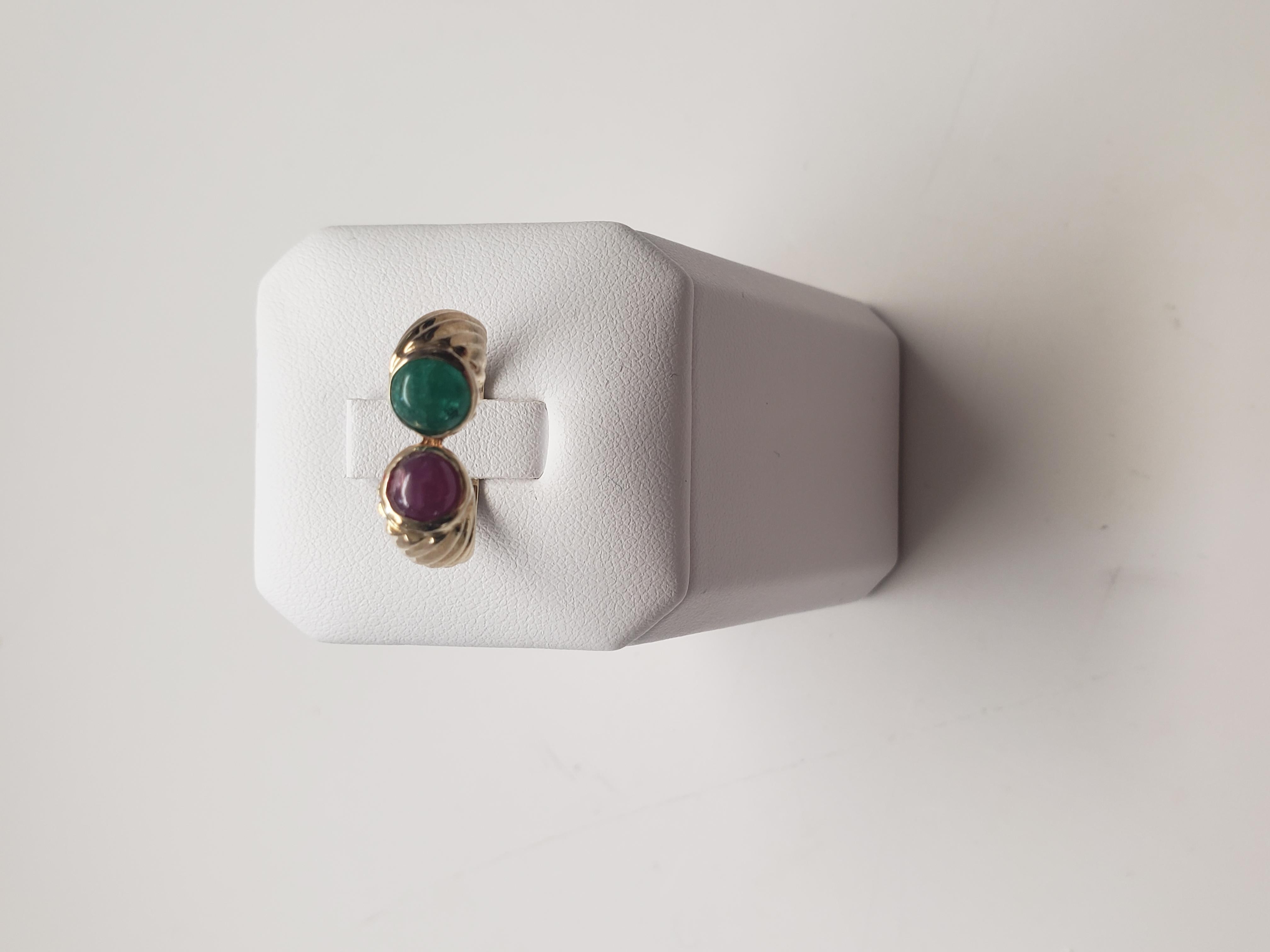 Dieser atemberaubende Ring aus massivem 14-karätigem Gelbgold ist mit einem natürlichen Rubin und einem Smaragd in einer Lünettenfassung besetzt. Die roten und grünen Edelsteine ergänzen sich wunderbar und machen das Schmuckstück zu einem