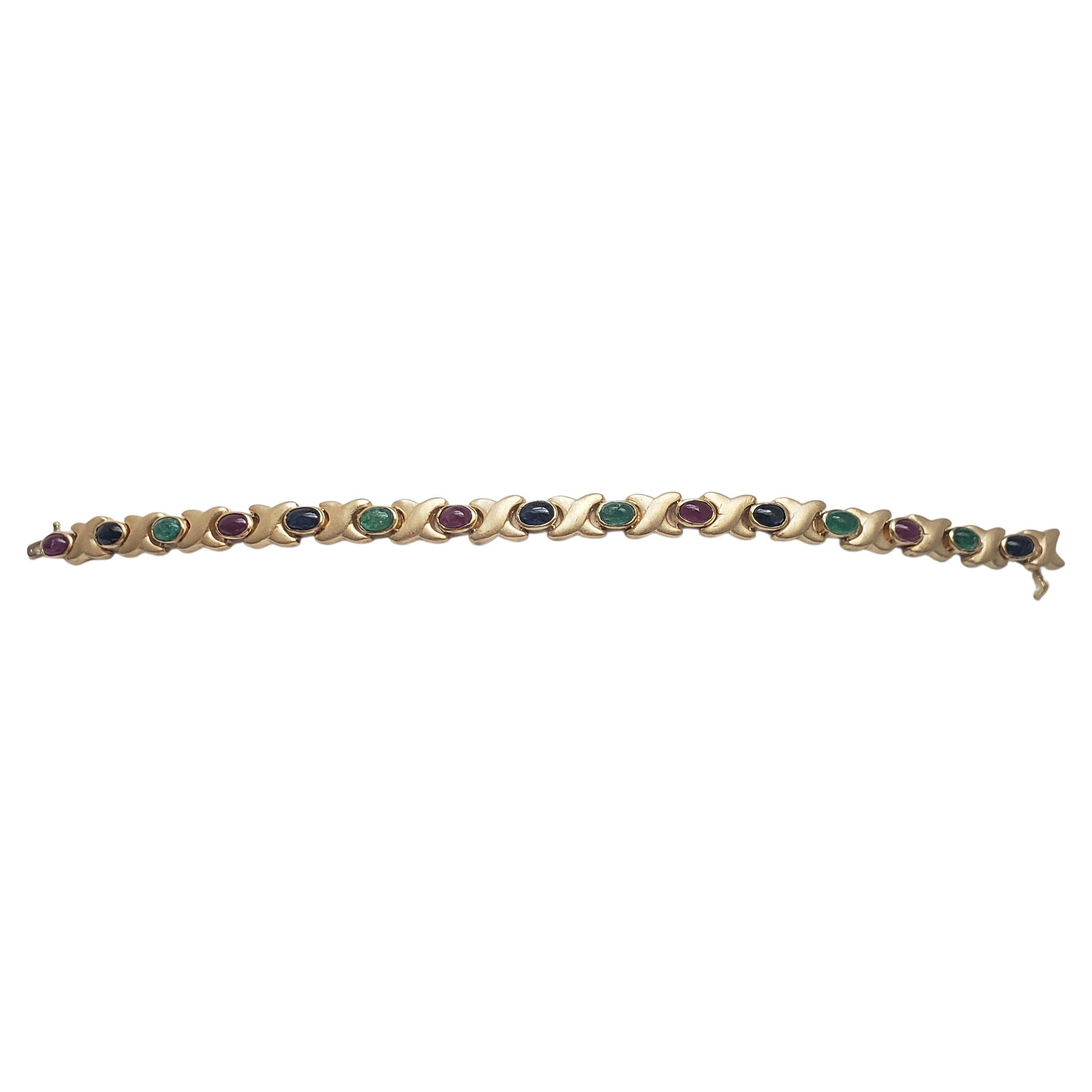 Ce magnifique bracelet de LaFrancee est un véritable chef-d'œuvre. La monture en or jaune massif 14k lui confère un aspect luxueux, tandis que les pierres précieuses naturelles que sont le rubis, le saphir et l'émeraude ajoutent une touche