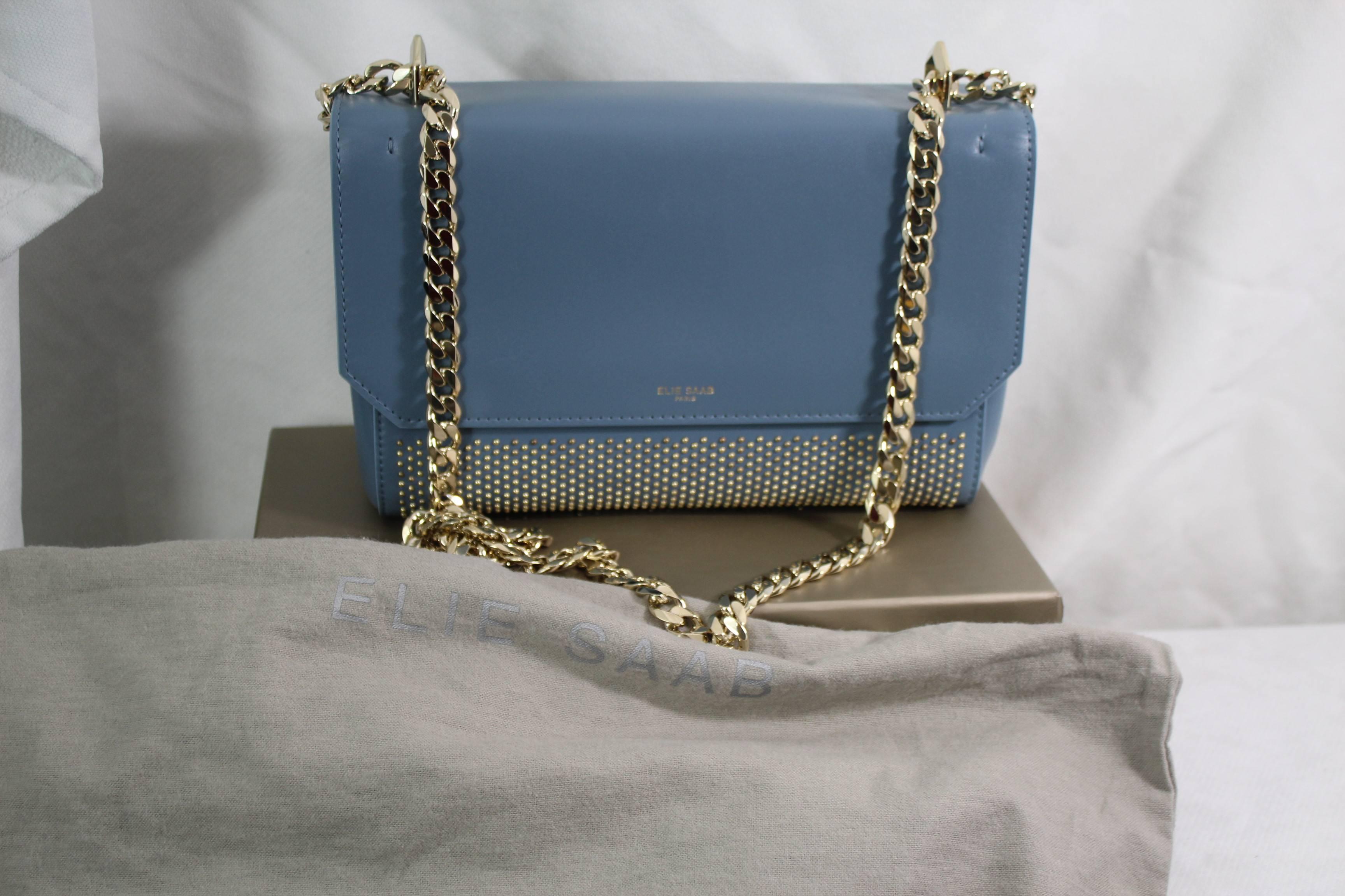 New never used Elie Saab leather bag in a really nice bleu color and golden hardware and studs.

Sold with box and dust baag and papers.

Size 23x15 cm