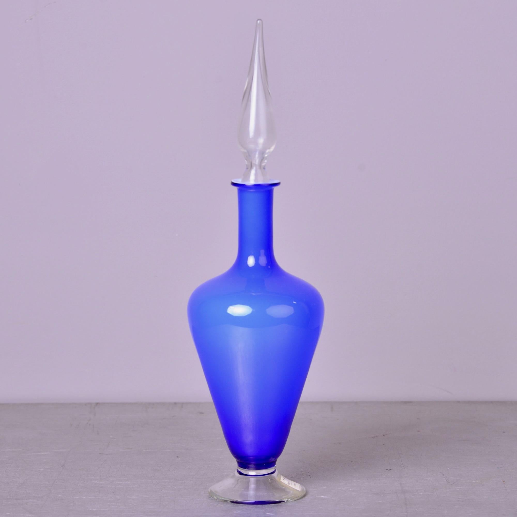 Bouteille bleue en verre de Murano des années 1960, avec base et bouchon transparents. Étiquettes d'inventaire originales du détaillant et autocollant Balboa. Aucun défaut trouvé. Plusieurs bouteilles de ce style et de cette couleur disponibles au