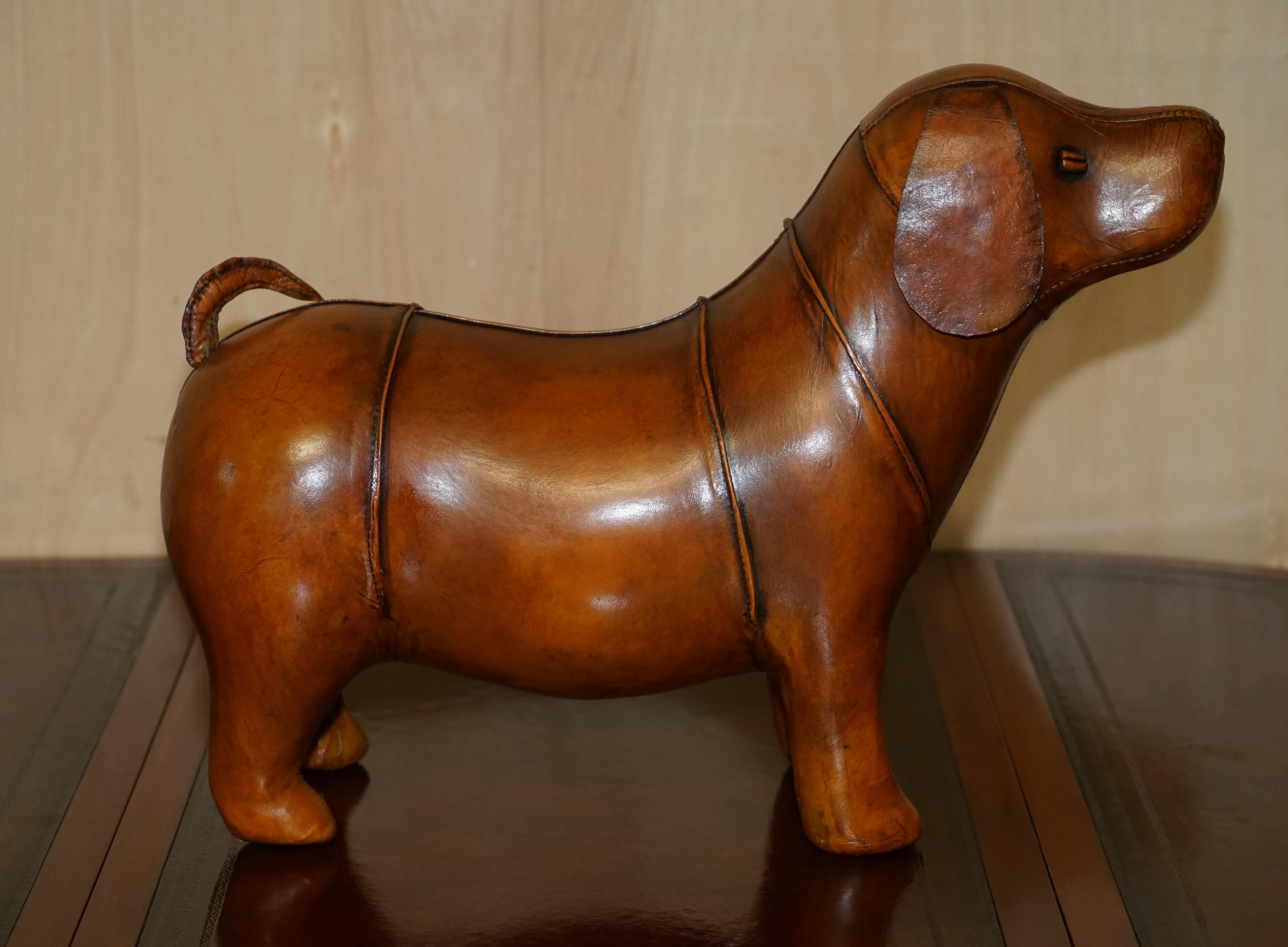 We are delighted to offer for sale this absolutely sublime new old stock original Liberty’s London Omersa style brown leather hand dyed Sausage dog footstool.

These come in varying sizes there is a quite unpractical extra-large size which is