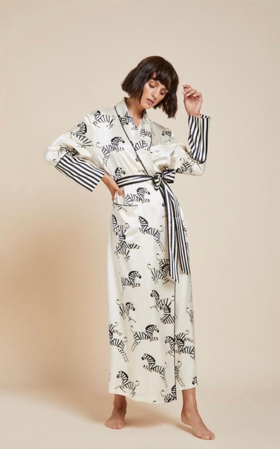 This gorgeous Olivia von Halle silk robe is crafted in 19 Momme silk and printed with the famous zebra print

Rare piece, sold out immediately

-Cream printed silk full-length robe with silk sash 
-Jet Black piped silk trims 
-Shawl lapel, angled