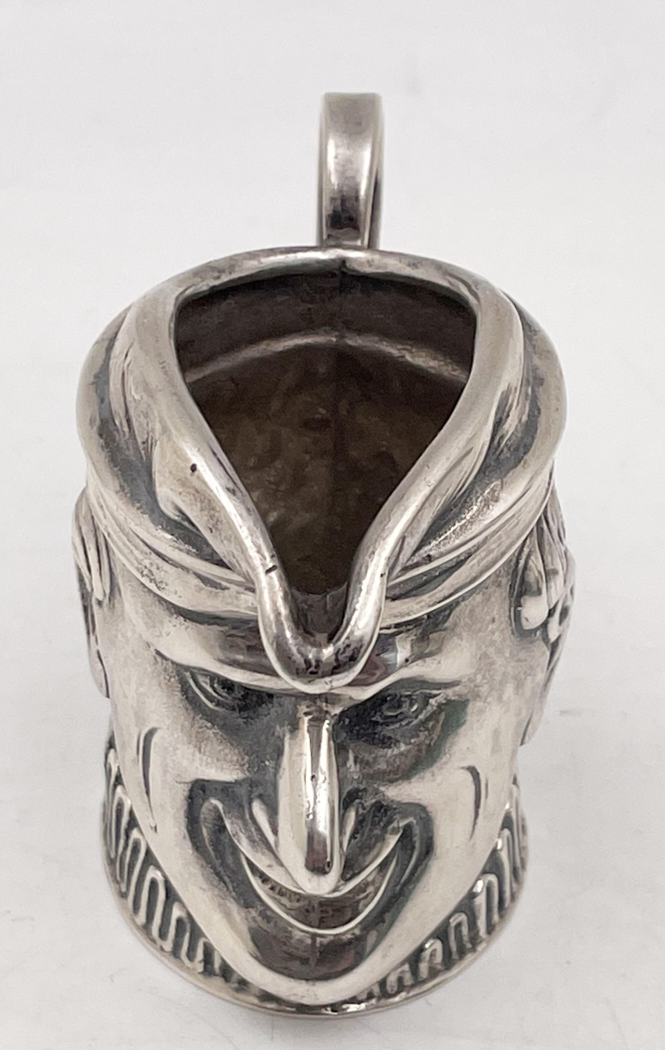 Toby jug / sterling silver creamer by New Orleans Silversmiths depicting a well-executed, human face with a long nose, measuring 2 1/8'' in height by 2 3/4'' from handle to spout, and bearing hallmarks as shown. 

We hand polish all items before