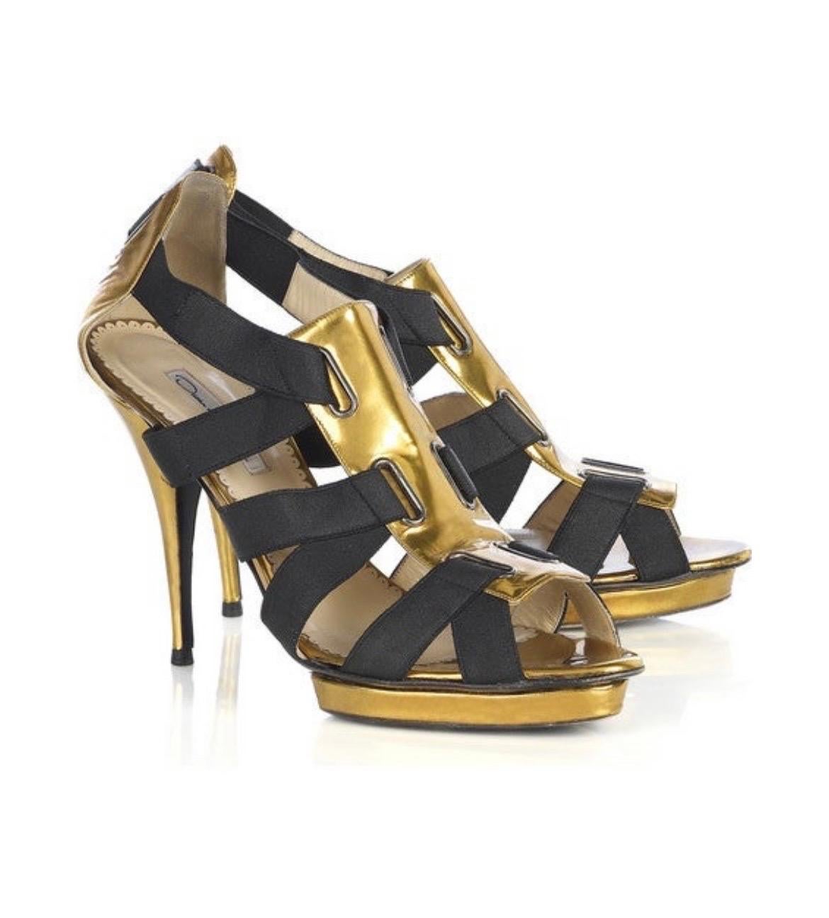 OSCAR DE LA RENTA
Oscar de la Renta black and gold patent leather corset sandals. 
Wear these fabulous look-at-me heels to add the Midas touch to an elegant evening ensemble. 
Heel measures approximately 110mm / 4.5 inches with a 20mm / 1 inch