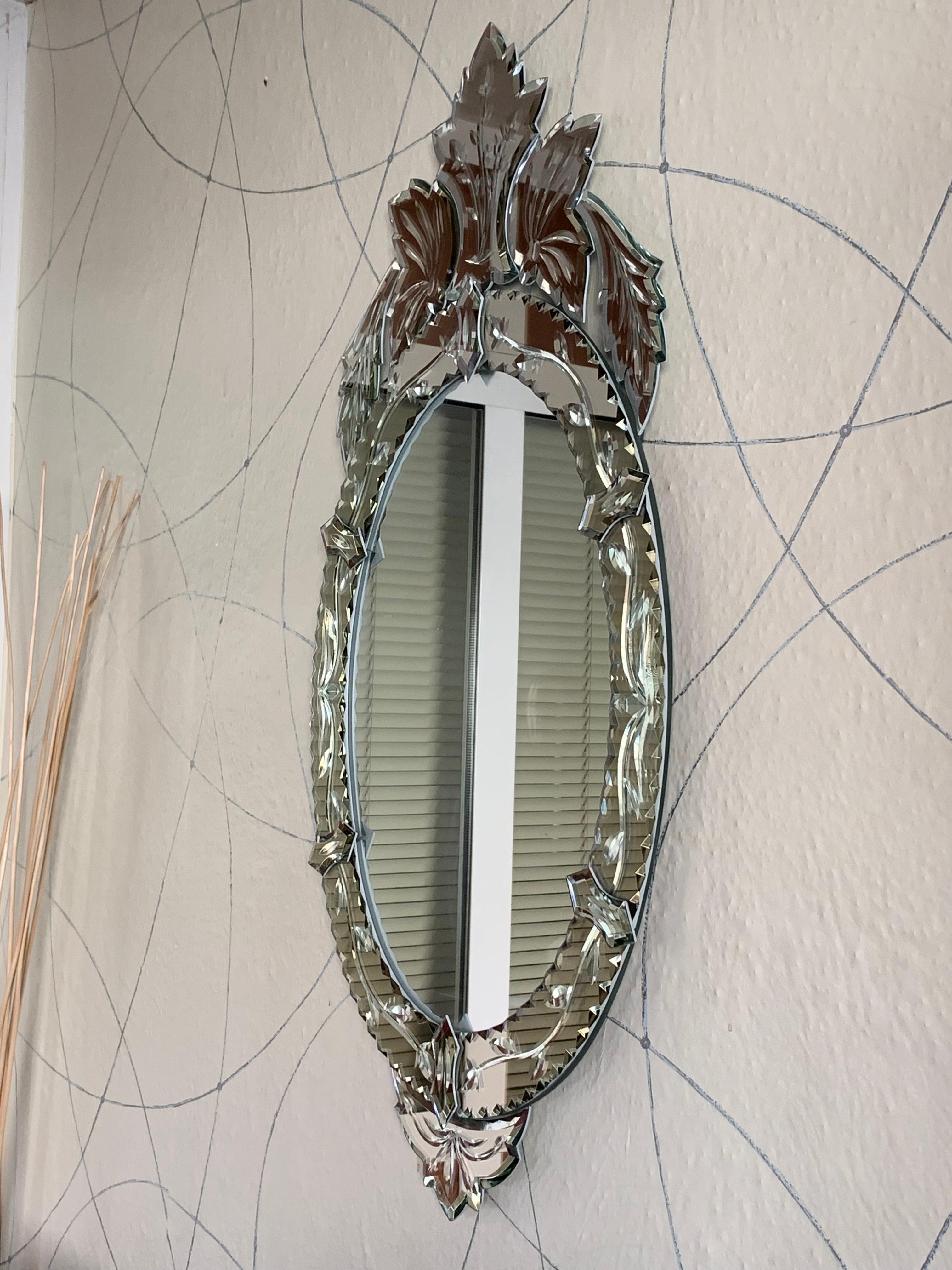 Venetian glass mirror with shaped and engraved border mirror glass surmounted by engraved mirrored naturalistic crests.
