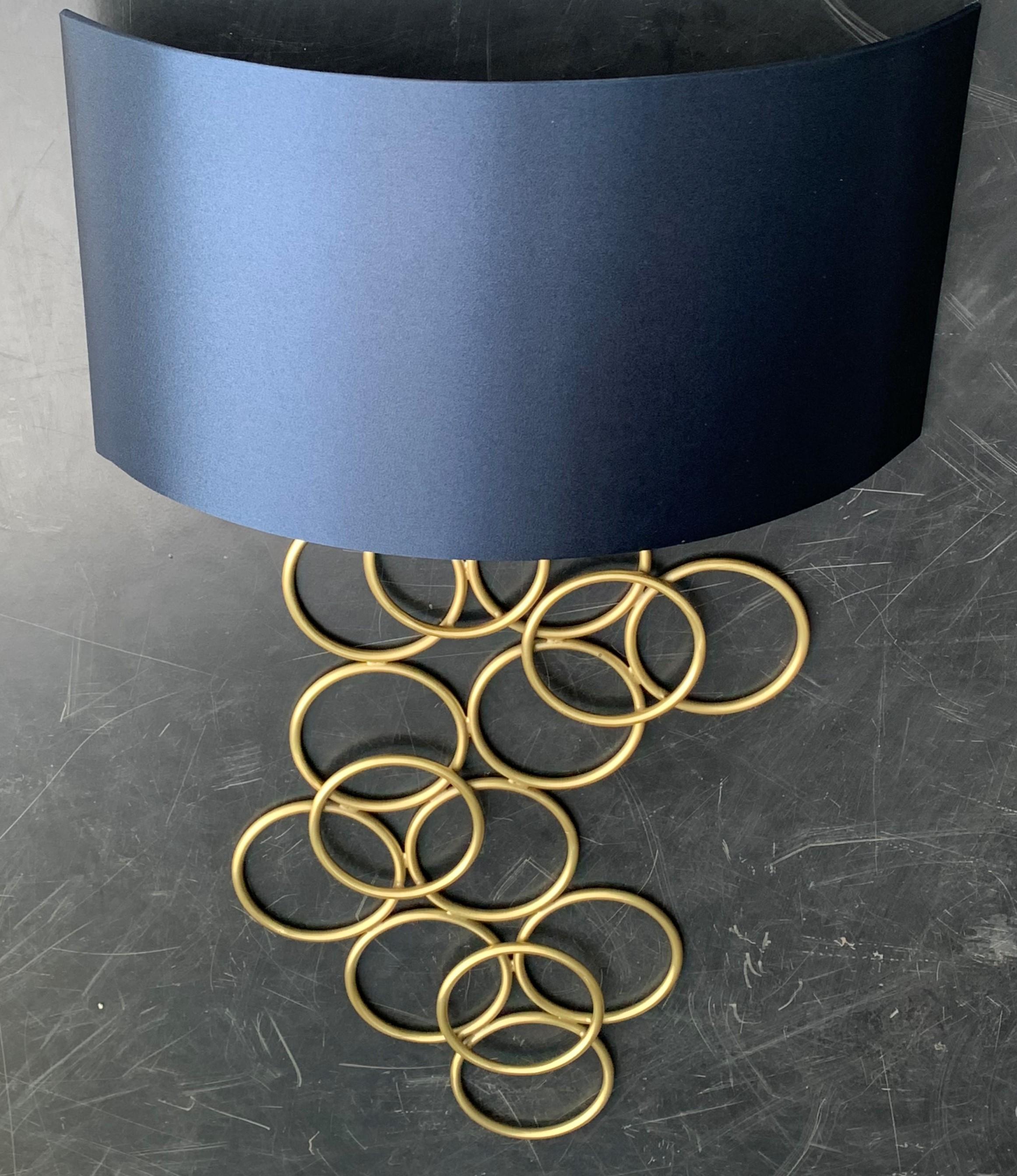 Nuova coppia di appliques in metallo dorato con paralume in seta blu.