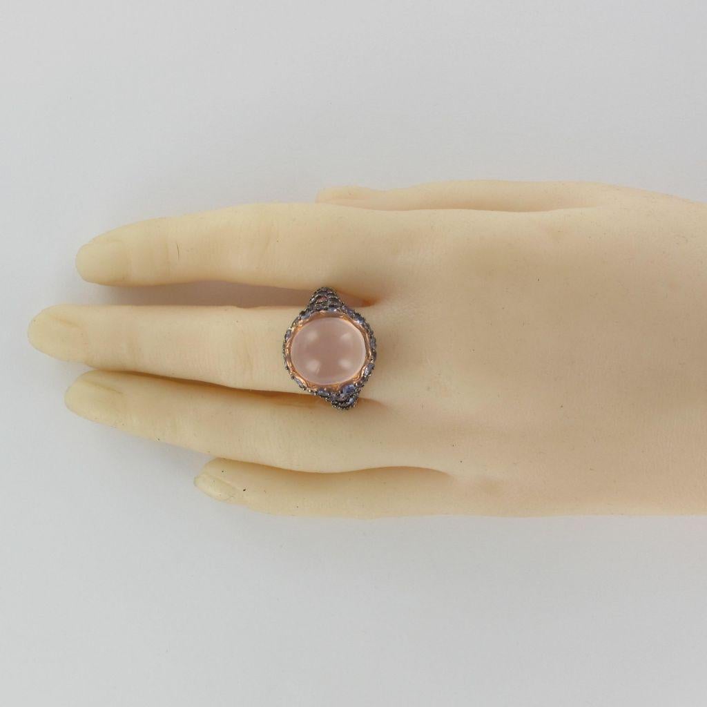Ring in silver.
This beautiful silver ring is set on its top of a pink quartz cabochon surrounded by a pavement of round pink sapphires, round tanzanites and round amethysts.
Total weight of precious stones: 12.75 carats approximately.
Height: 1.2