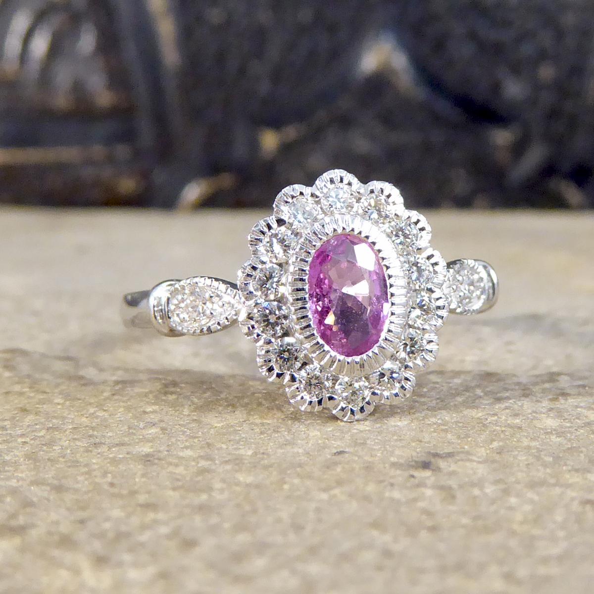 This pretty pink Sapphire centre weighs 0.40ct and is an Oval cut gemstone. It has a surround of Diamonds weighing 0.25ct in total of modern brilliant cut Diamonds that are clear and bright. Brand new and never worn, all the gems are set in a rub