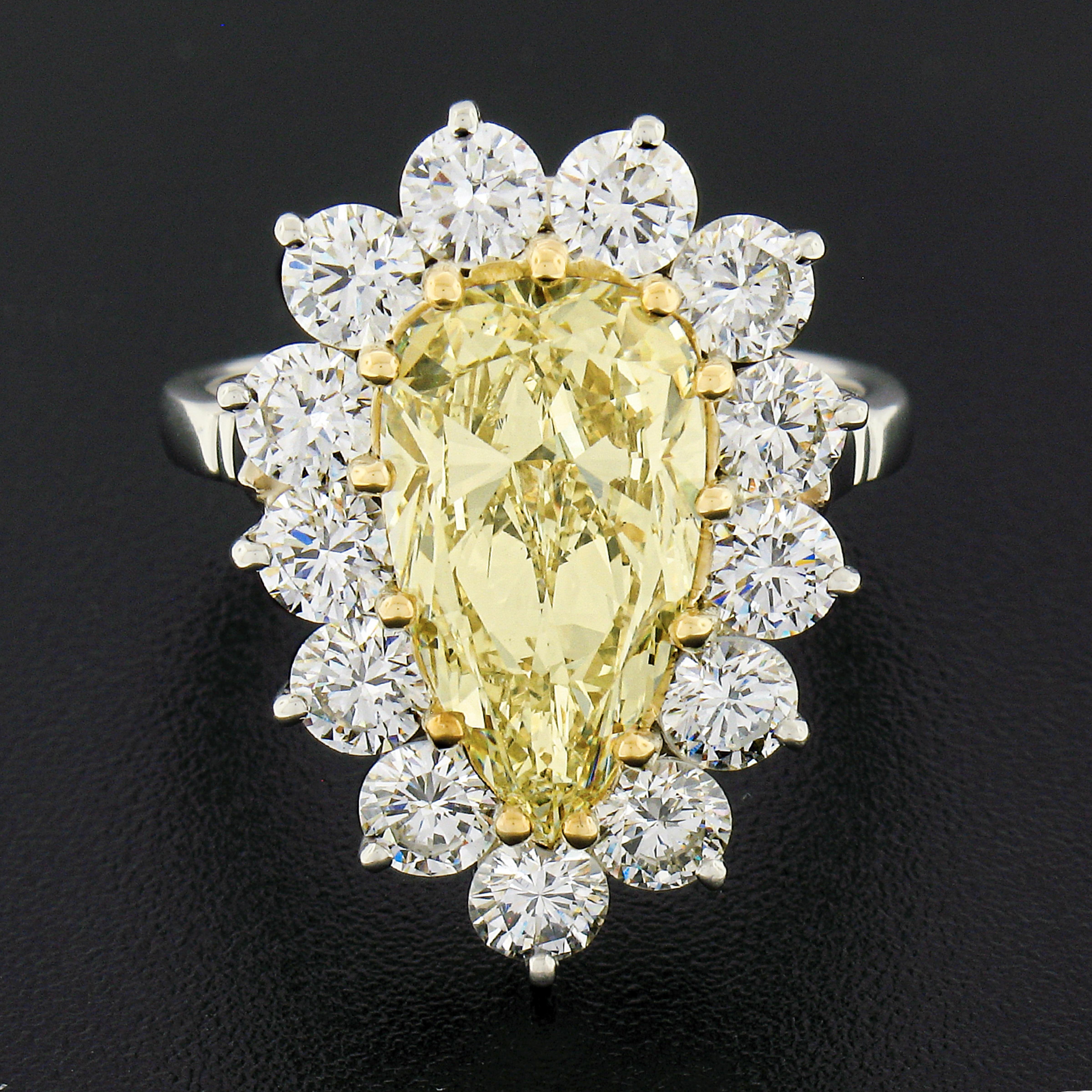You are looking at a truly breathtaking custom designed engagement ring that is newly handcrafted from solid platinum with an 18k yellow gold center basket and prongs that carries a STUNNING, GIA certified, fancy light yellow diamond. This