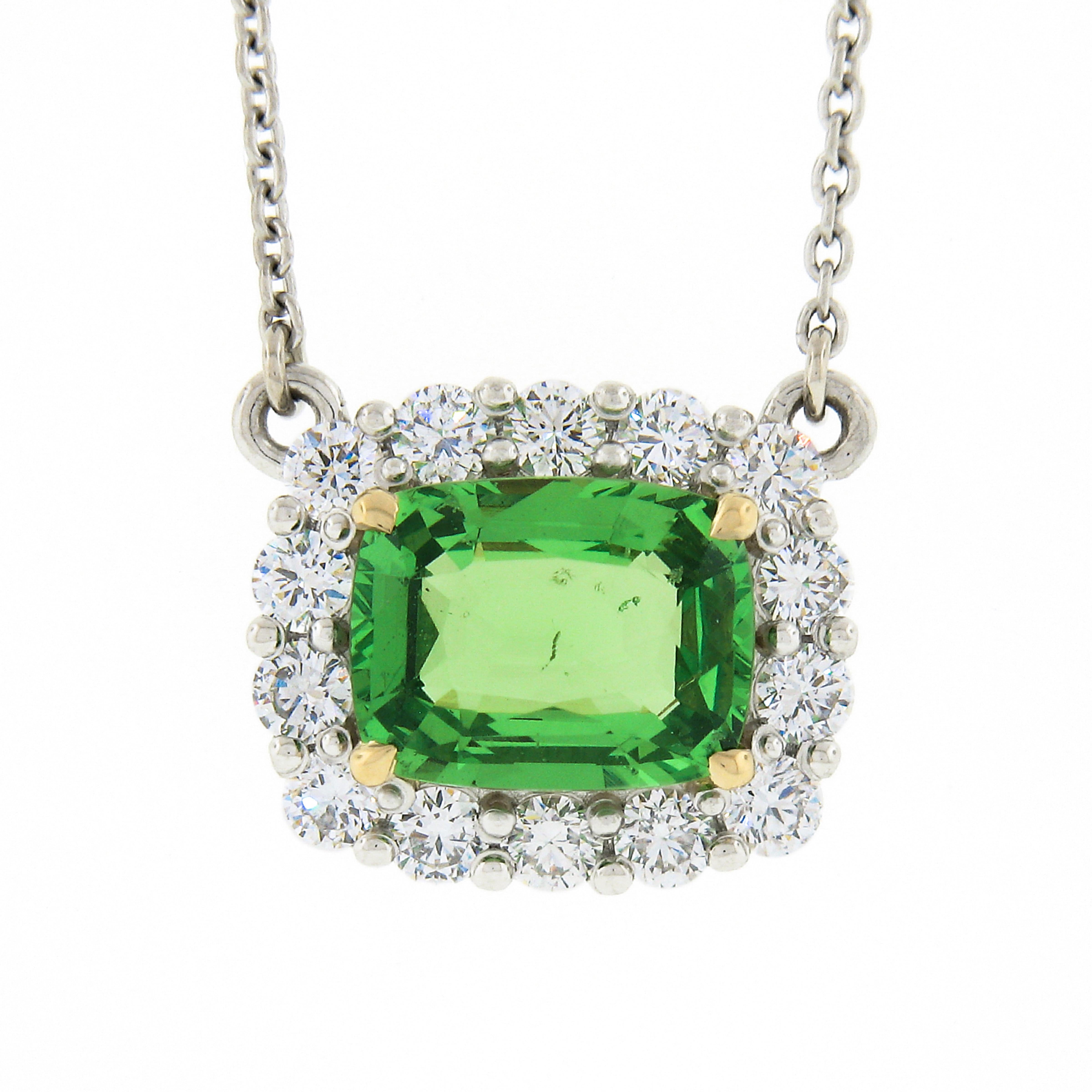Here we have an absolutely gorgeous and very well made pendant necklace that is newly crafted from .950 platinum with a solid 18k yellow gold center basket that carries a stunning, GIA certified, natural tsavorite solitaire stone surrounded by a
