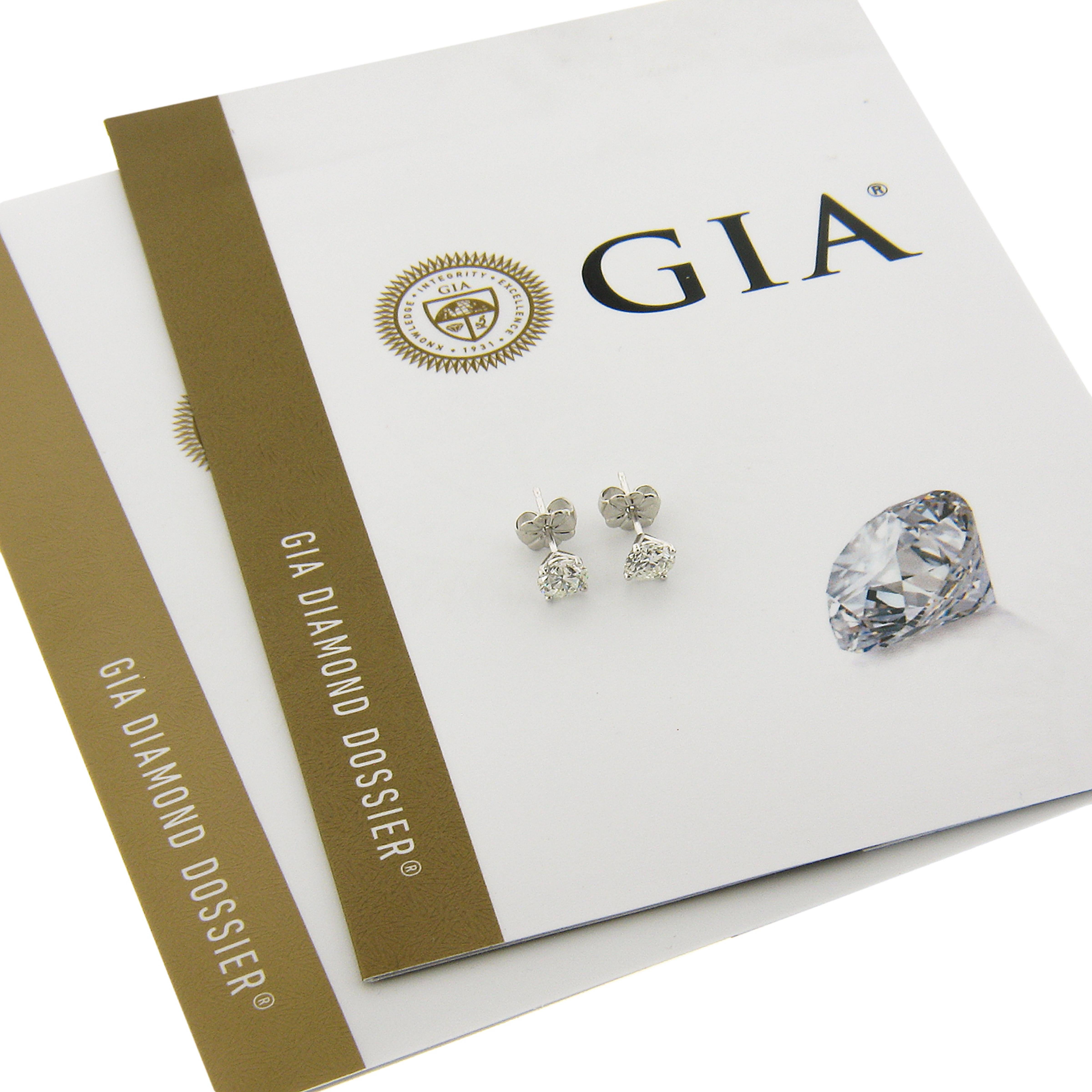 This elegant pair of diamond stud earrings was newly crafted from solid platinum and features two brilliant and fiery, GIA certified round diamonds. These very fine quality diamonds total exactly 1.02 carats in weight and they come with the original