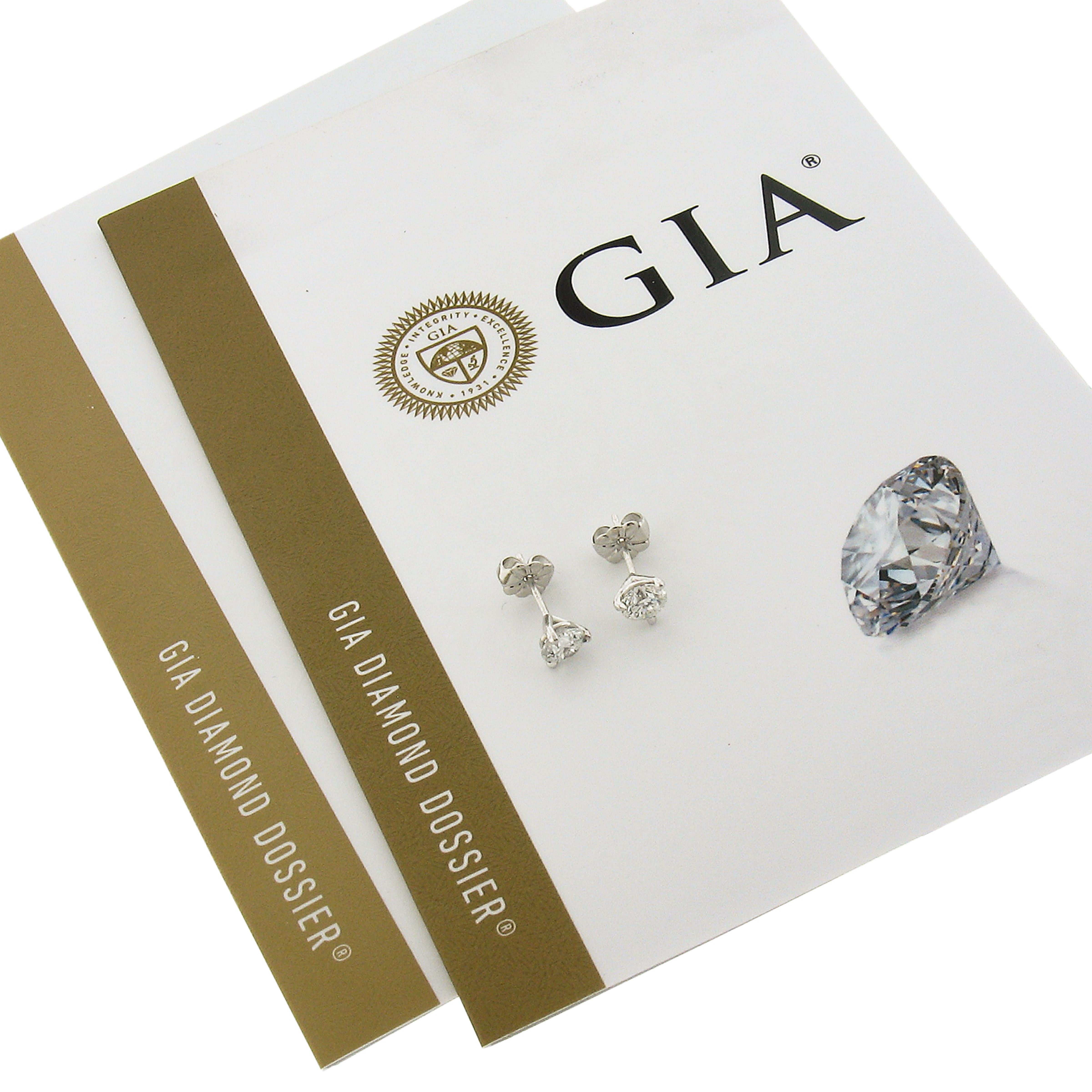 This elegant pair of diamond stud earrings was newly crafted from solid platinum and features two brilliant and fiery, GIA certified, round martini prong set diamonds. These very fine quality diamonds total exactly 1.03 carats in weight. This pair