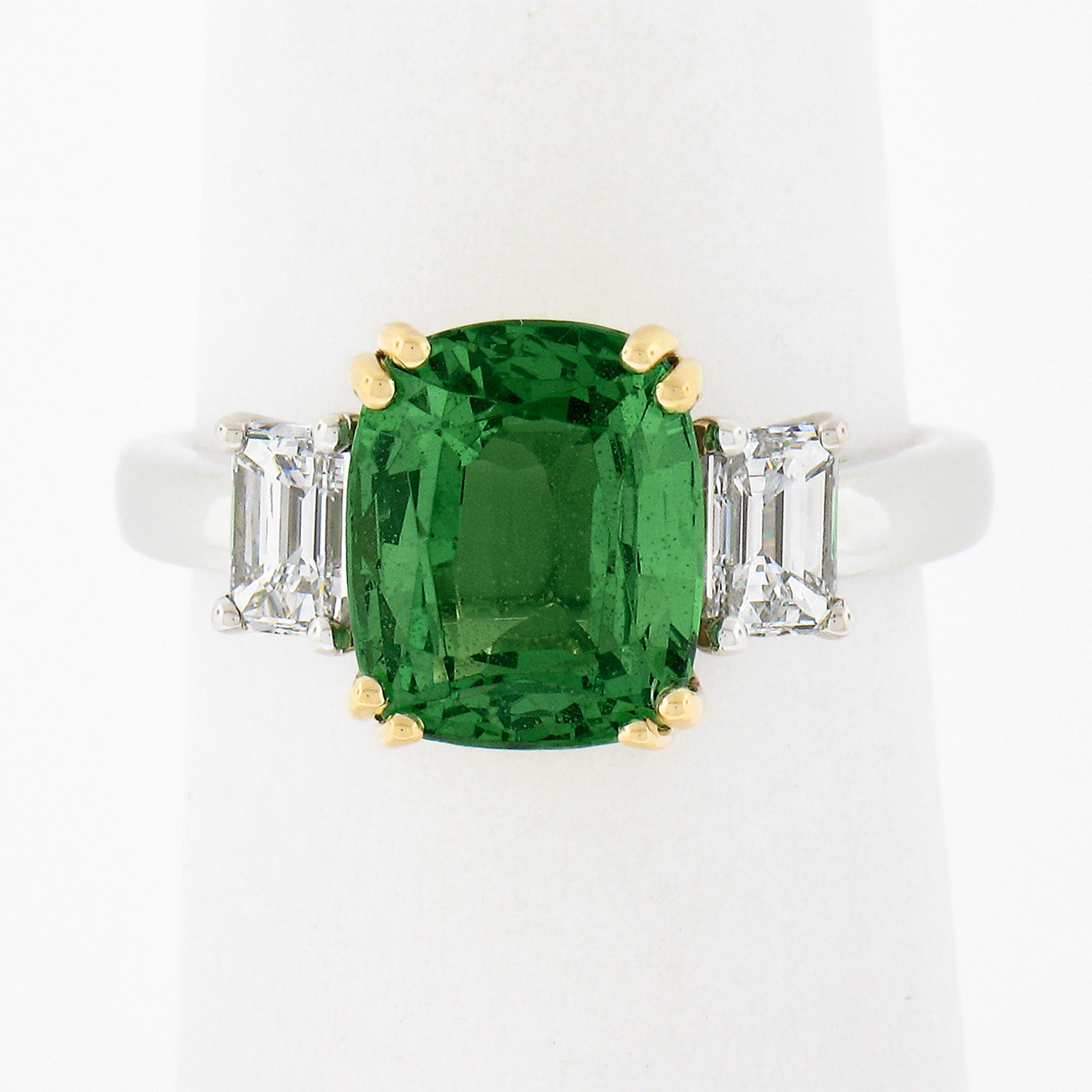 This fancy and truly fine quality green tsavorite and diamond custom made ring is crafted in solid platinum with a solid 18k yellow gold center basket setting. The ring features a natural, GIA certified, cushion cut green tsavorite that weighs