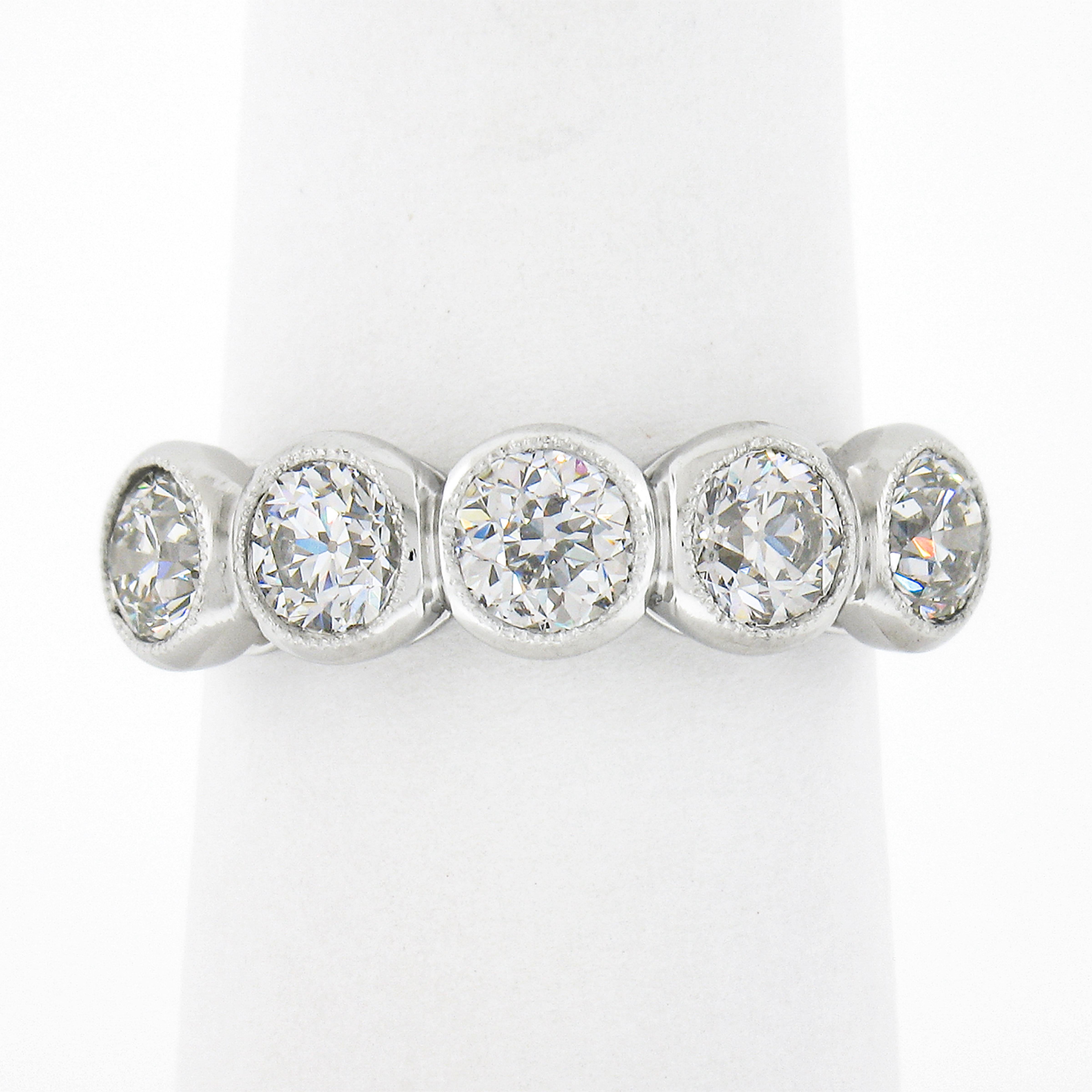 This magnificent diamond band ring was newly crafted from solid platinum and features 5 old European cut diamonds neatly bezel set with delicate milgrain etching across its top. Each of these fiery diamond shows a very nice large size, totaling
