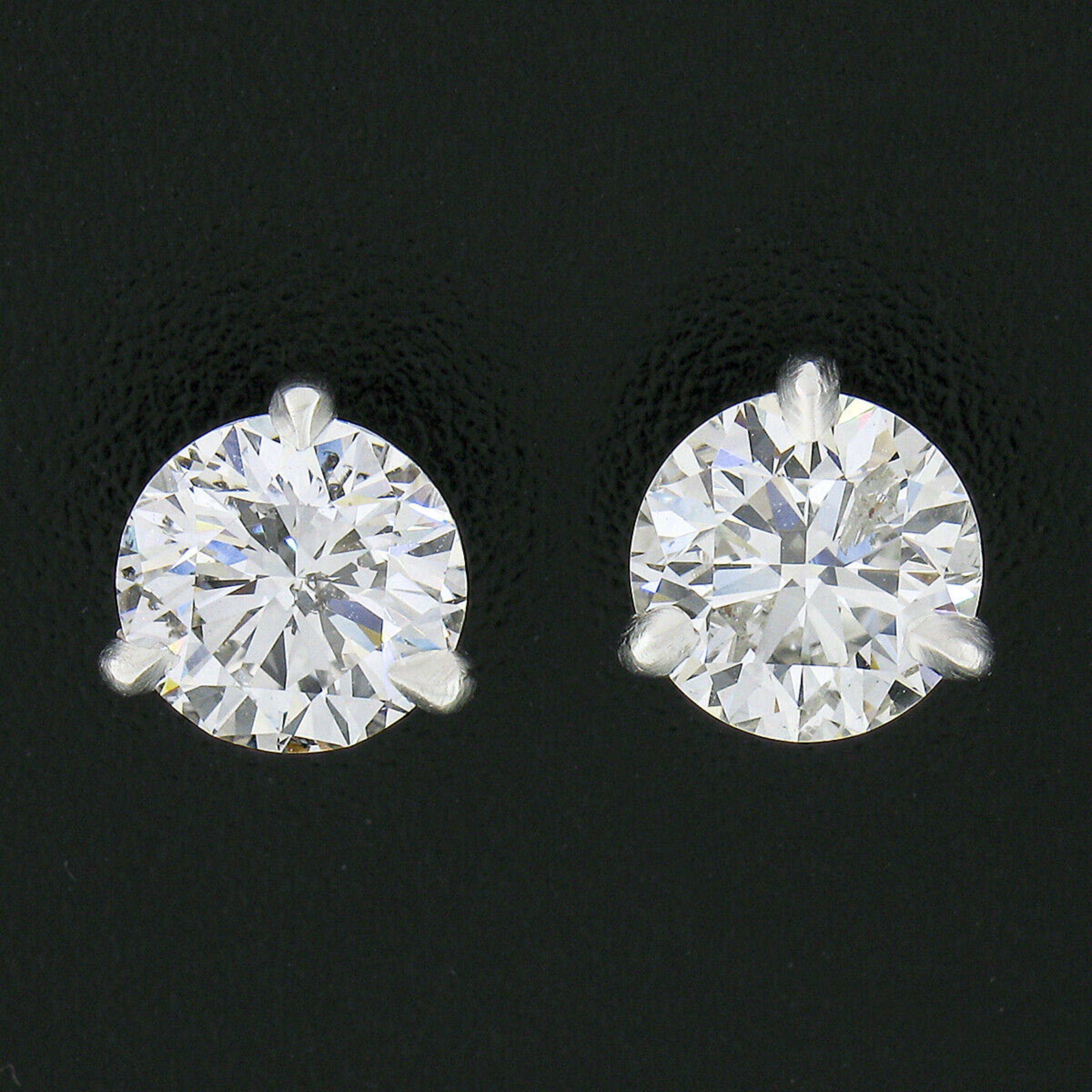 This stunning pair of diamond stud earrings was newly crafted from solid 950 platinum and features two exceptionally brilliant and fiery GIA certified round brilliant diamonds. The diamonds total exactly 2.05 carats in weight (each weighing over 1