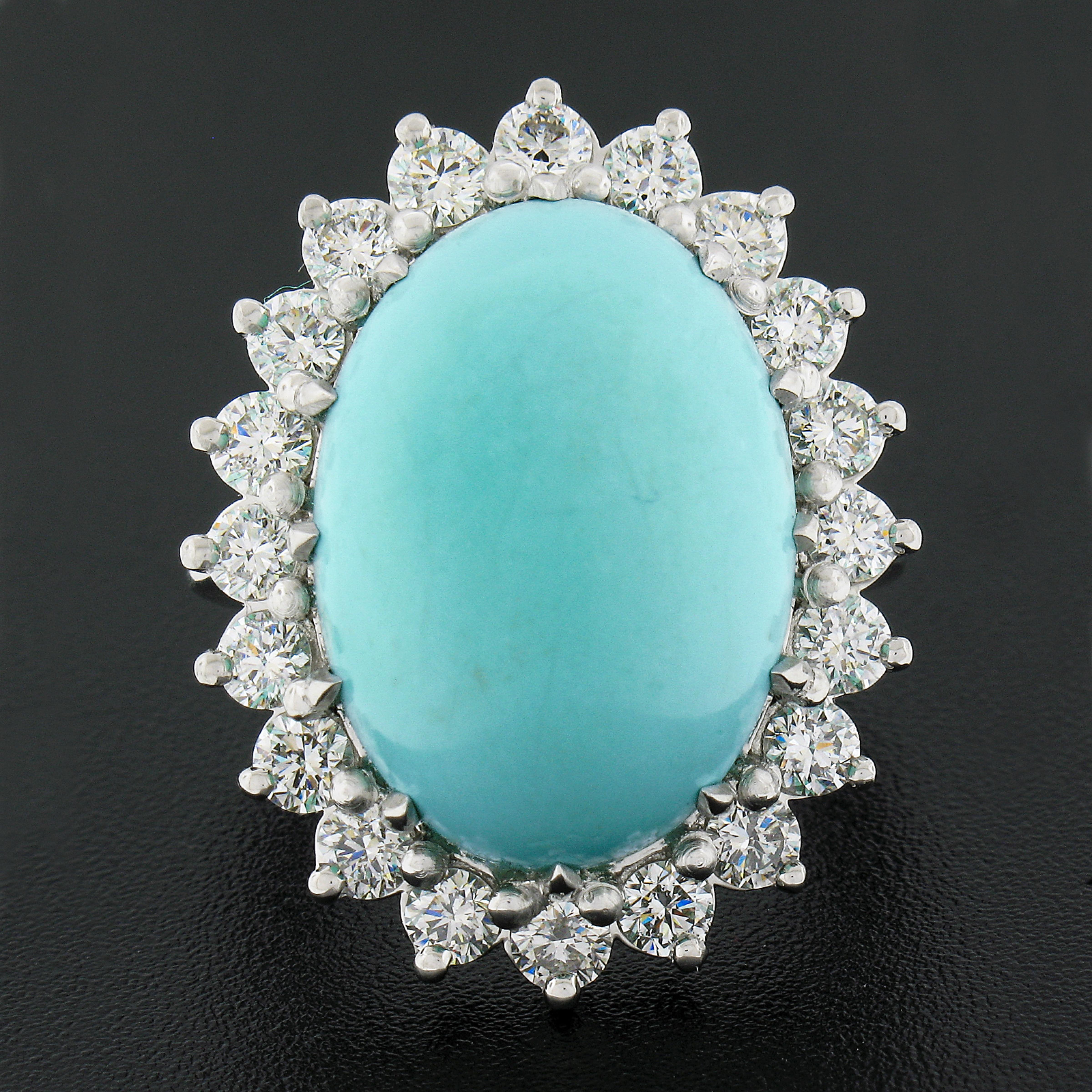 This magnificent, large, and fancy cocktail ring is newly crafted in solid platinum and features a breathtaking natural turquoise stone neatly set with multiple sturdy prongs at the center of super lively diamond halo design. The turquoise displays