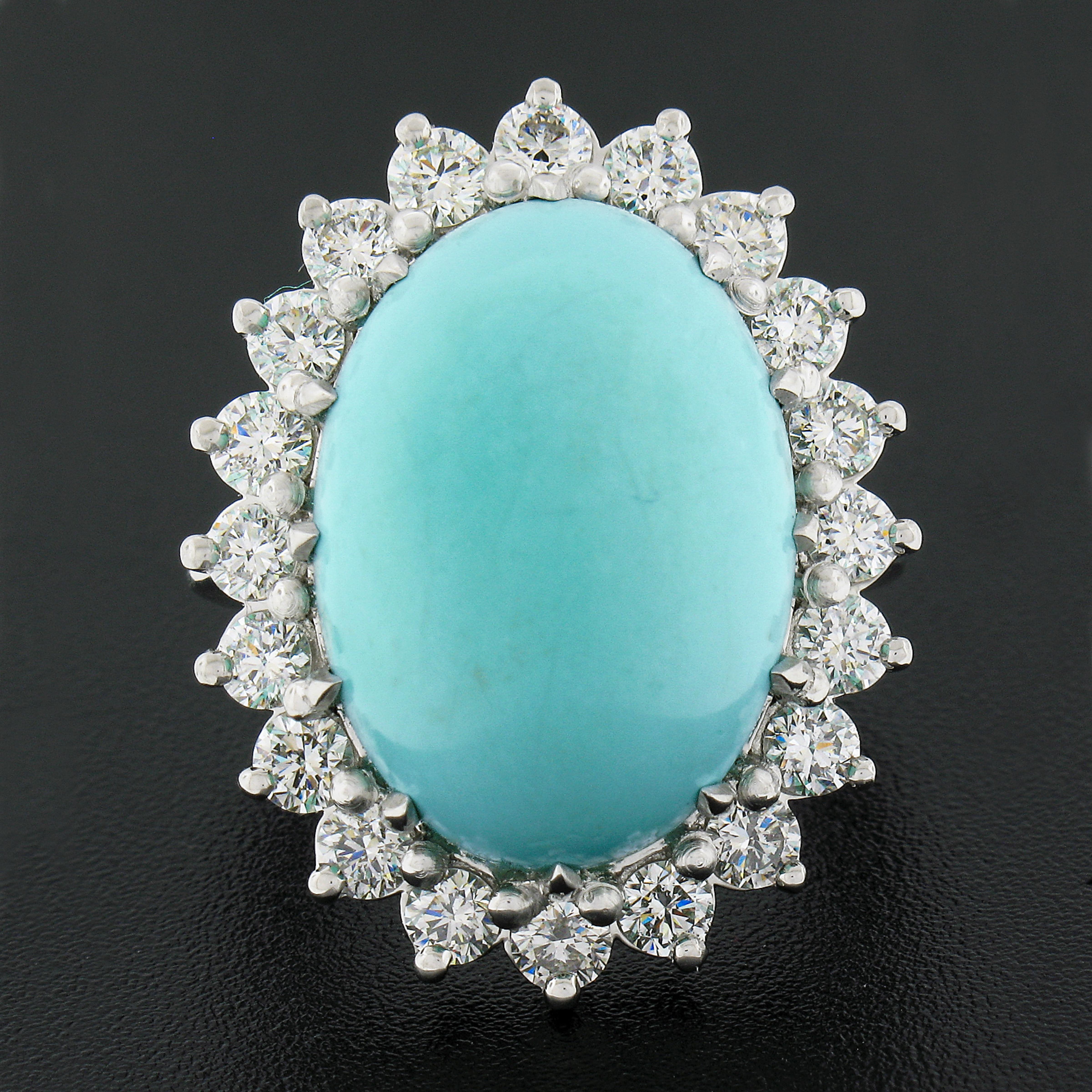 This magnificent, large, and fancy cocktail ring is newly crafted in solid platinum and features a breathtaking natural turquoise stone neatly set with multiple sturdy prongs at the center of super lively diamond halo design. The turquoise displays