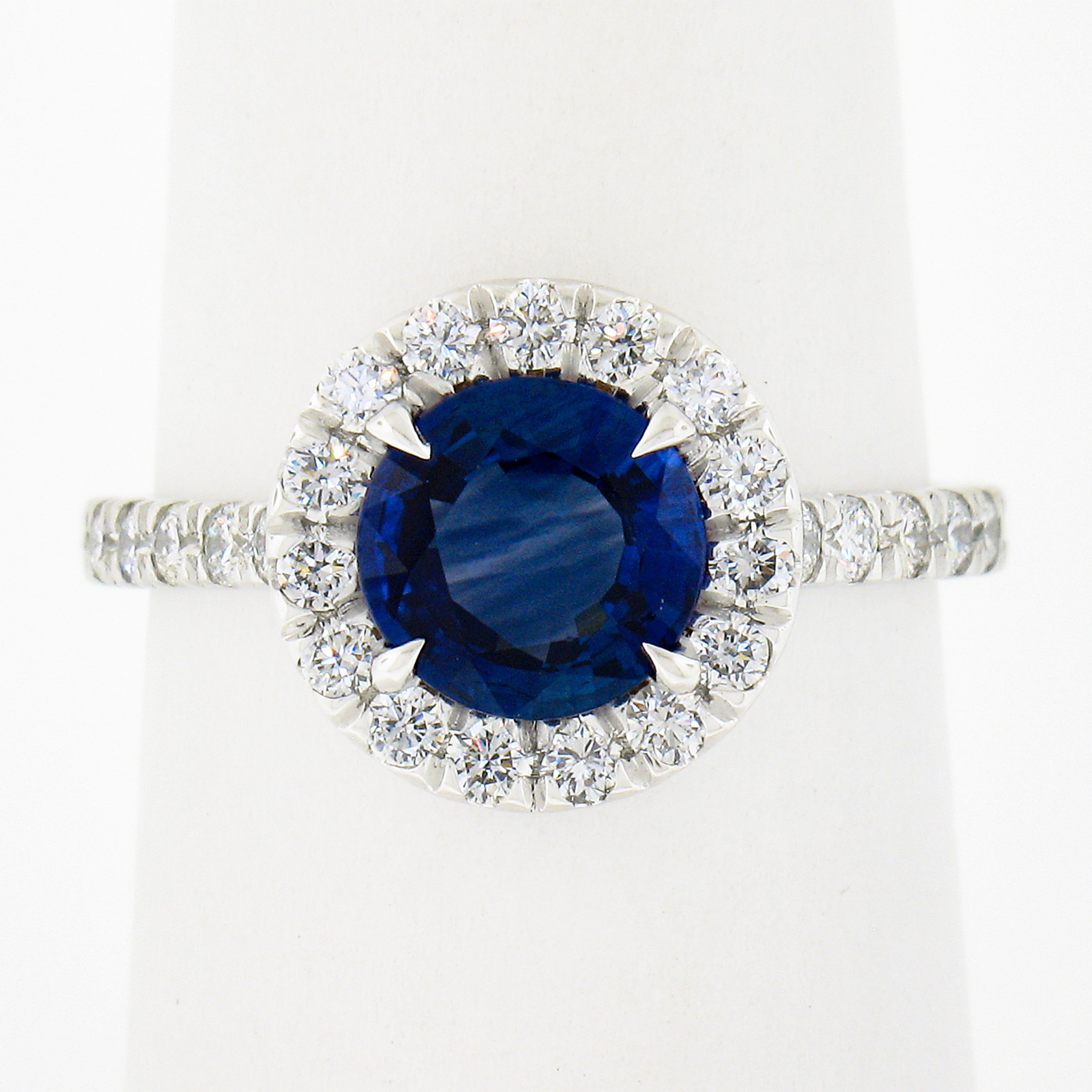 You are looking at a truly magnificent solid platinum sapphire and diamond low profile cocktail or engagement ring. The ring features a round brilliant cut (rare cut for sapphire) sapphire that is elegantly prong set at the center of a brilliant