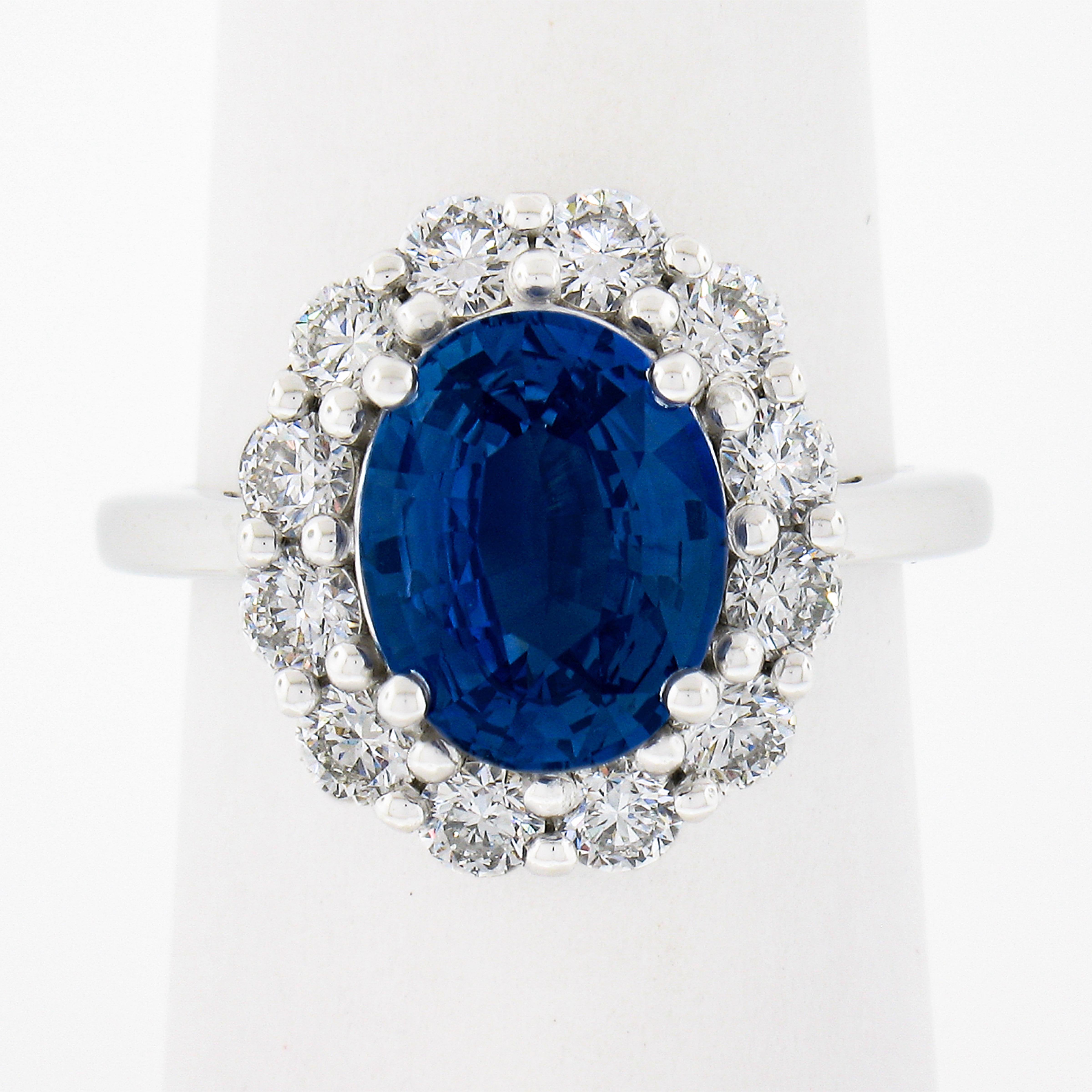 This stunning Princess Diana design engagement/cocktail ring is newly crafted in solid platinum. It features a mesmerizing and vibrant oval blue sapphire solitaire at its center which has been certified by GIA as weighing exactly 3.54 carats and