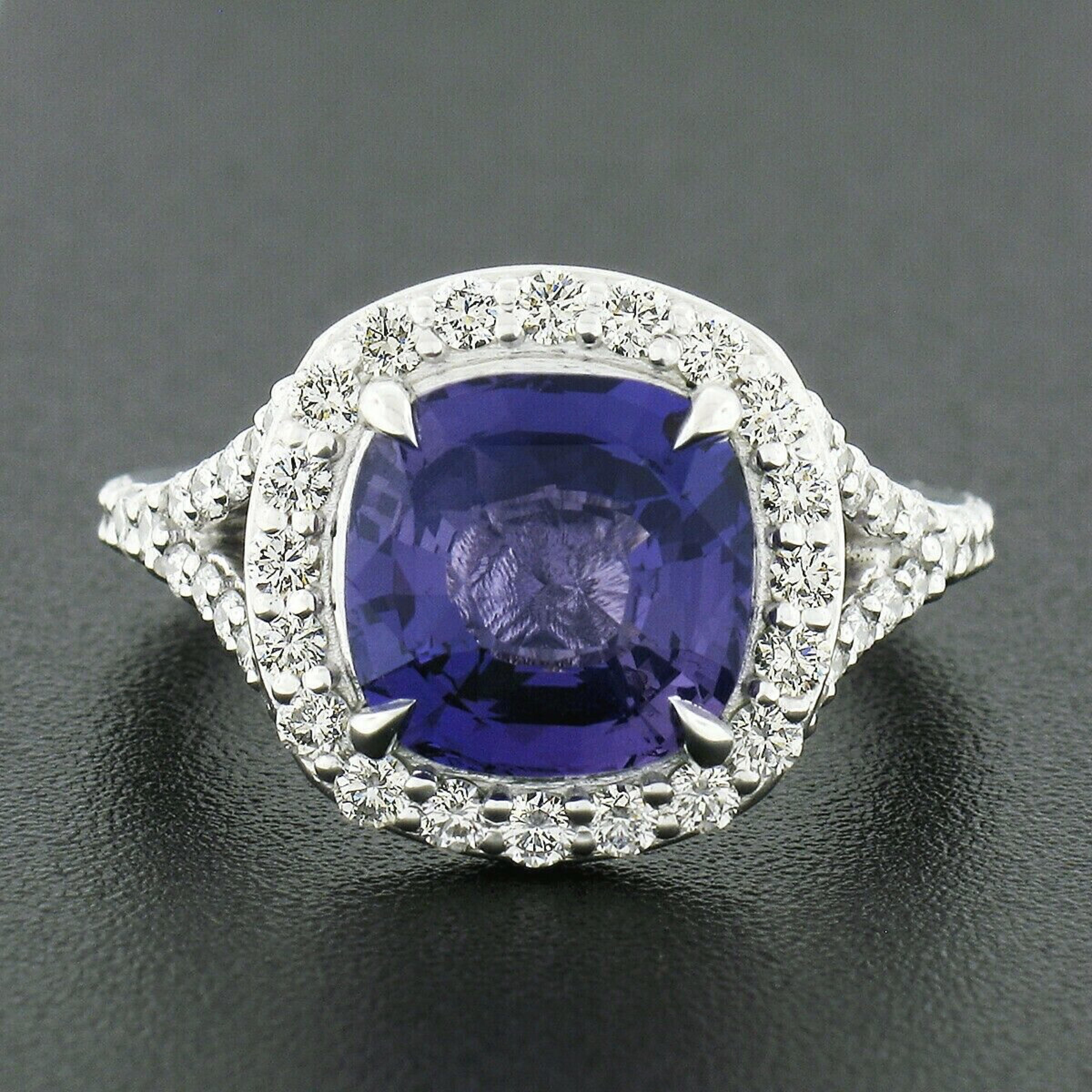 This is an absolutely breathtaking and well made engagement or cocktail ring that is newly crafted from solid platinum featuring a gorgeous natural purple sapphire at its center accented with super fine quality diamonds throughout. The cushion cut