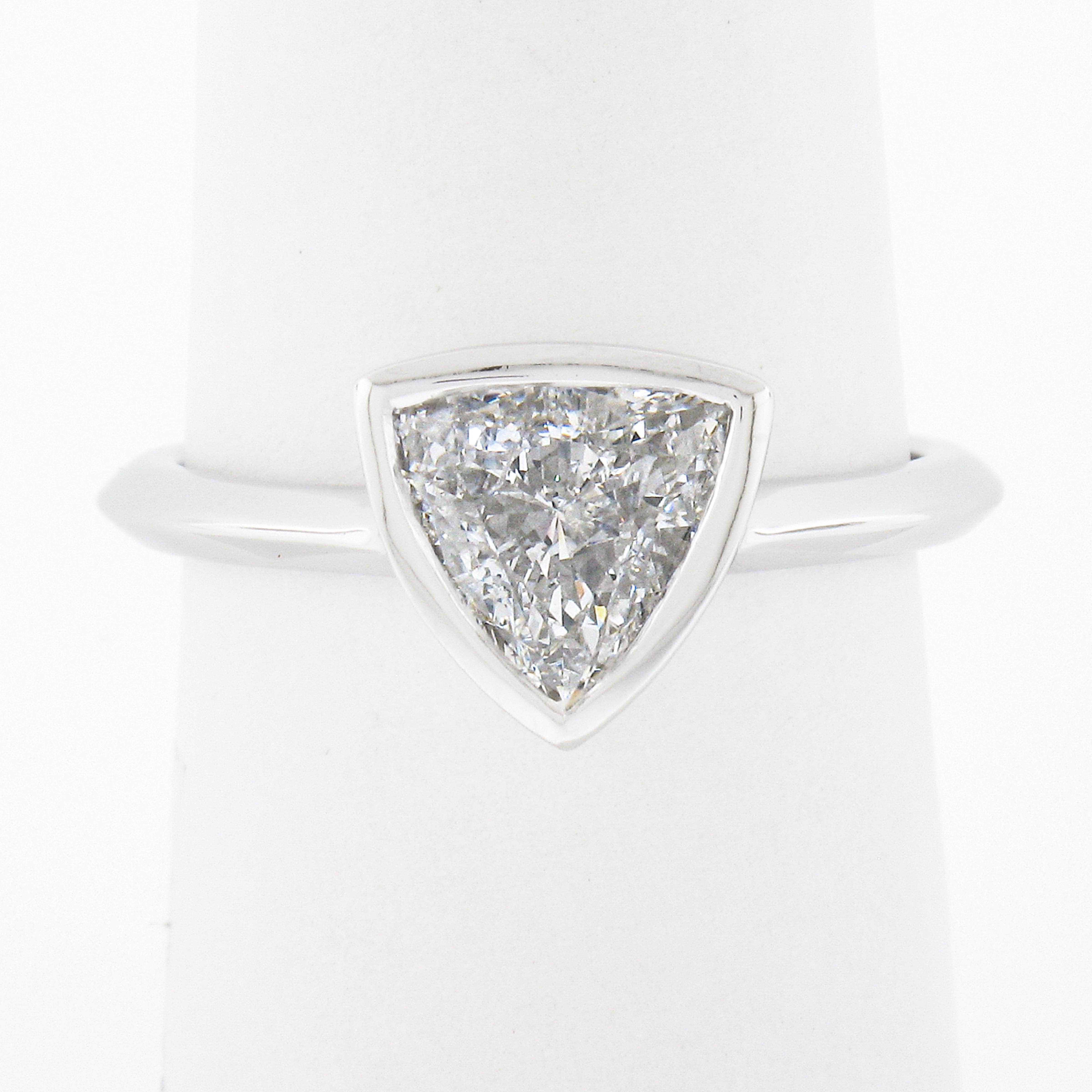 Here we have a simple, yet absolutely gorgeous, diamond solitaire ring that is newly crafted from solid platinum. The GIA certified solitaire has an amazing trillion cut and is neatly bezel set at the center of the ring, weighing exactly 1.01