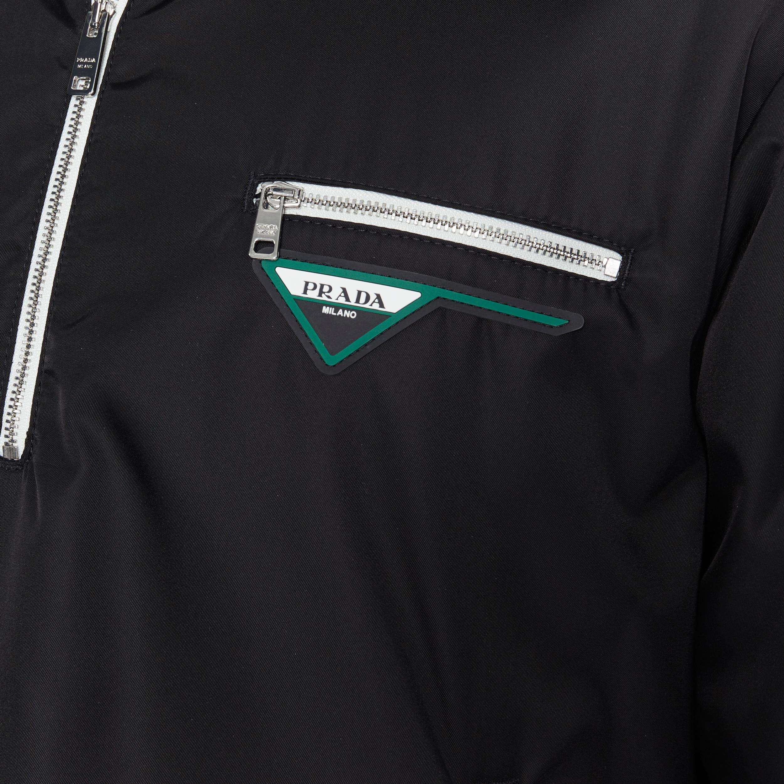 nuovo Prada 19 Runway nero triangolo logo gomma mezza zip pullover giacca IT52 XL 
Riferimento: TGAS/A05718 
Marchio: Prada 
Stilista: Miuccia Prada 
Collezione: 2018 Runway 
Materiale: Nylon 
Colore: nero 
Modello: Tinta unita 
Chiusura: zip