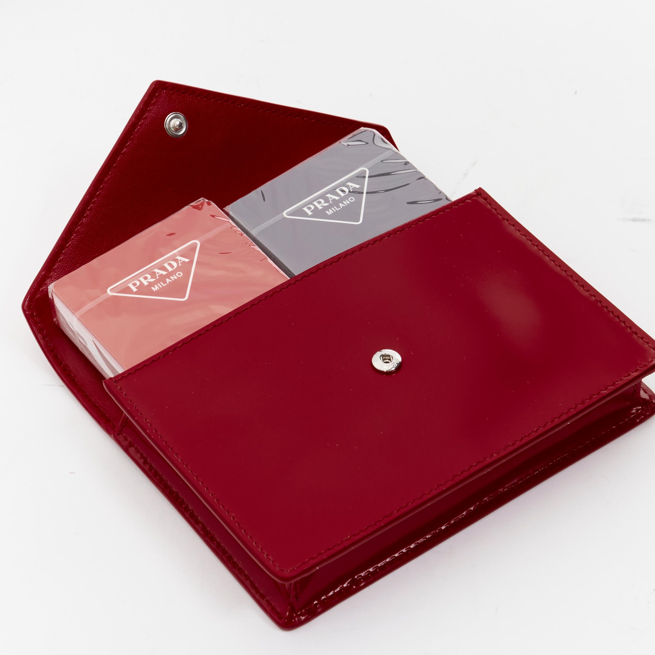 new PRADA 2021 2 pack playing cards red triangle logo envelop case pouch clutch 
Reference: JOMK/A00040 
Brand: Prada 
Designer: Miuccia Prada 
Material: Leather 
Color: Red 
Pattern: Solid 
Extra Detail: This playing card set with two decks comes