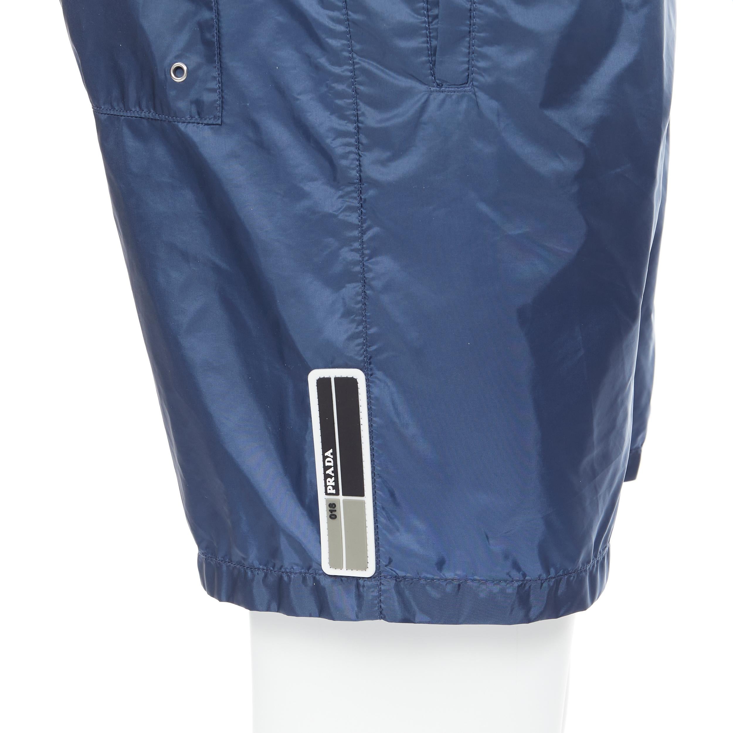 new PRADA dark blue burgundy stripe rubber logo swim shorts trunks IT44 XS 
Reference: TGAS/B00404 
Brand: Prada 
Designer: Miuccia Prada 
Material: Nylon 
Color: Blue 
Pattern: Solid 
Extra Detail: 3pocket design. Adjustable tab at back of waist