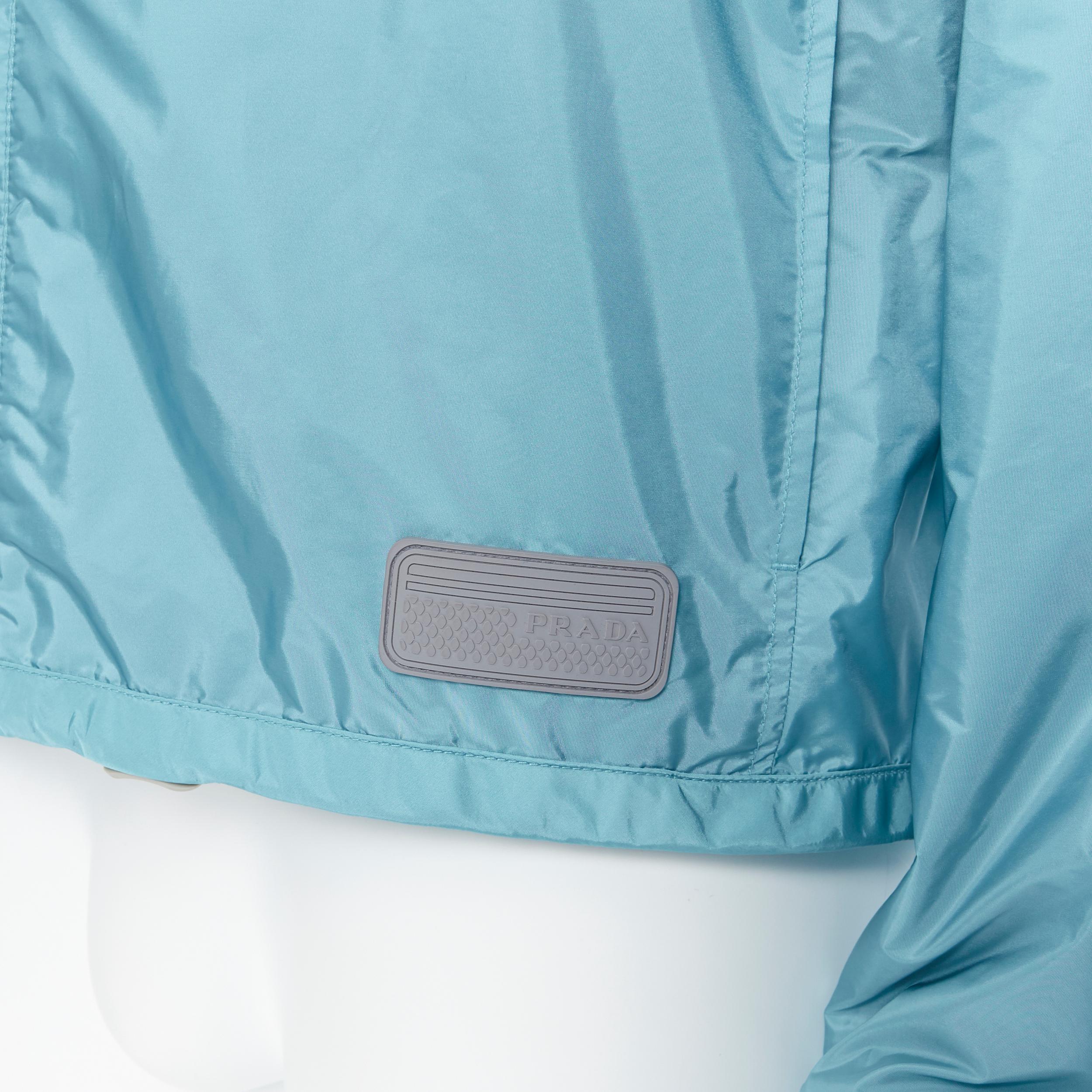 new PRADA Nylon teal blue rubber logo badge zip front light shell jacket IT50 
Reference: TGAS/A05739 
Brand: Prada 
Designer: Miuccia Prada 
Collection: 2017 
Material: Nylon 
Color: Blue 
Pattern: Solid 
Closure: Zip 
Extra Detail: Concealed