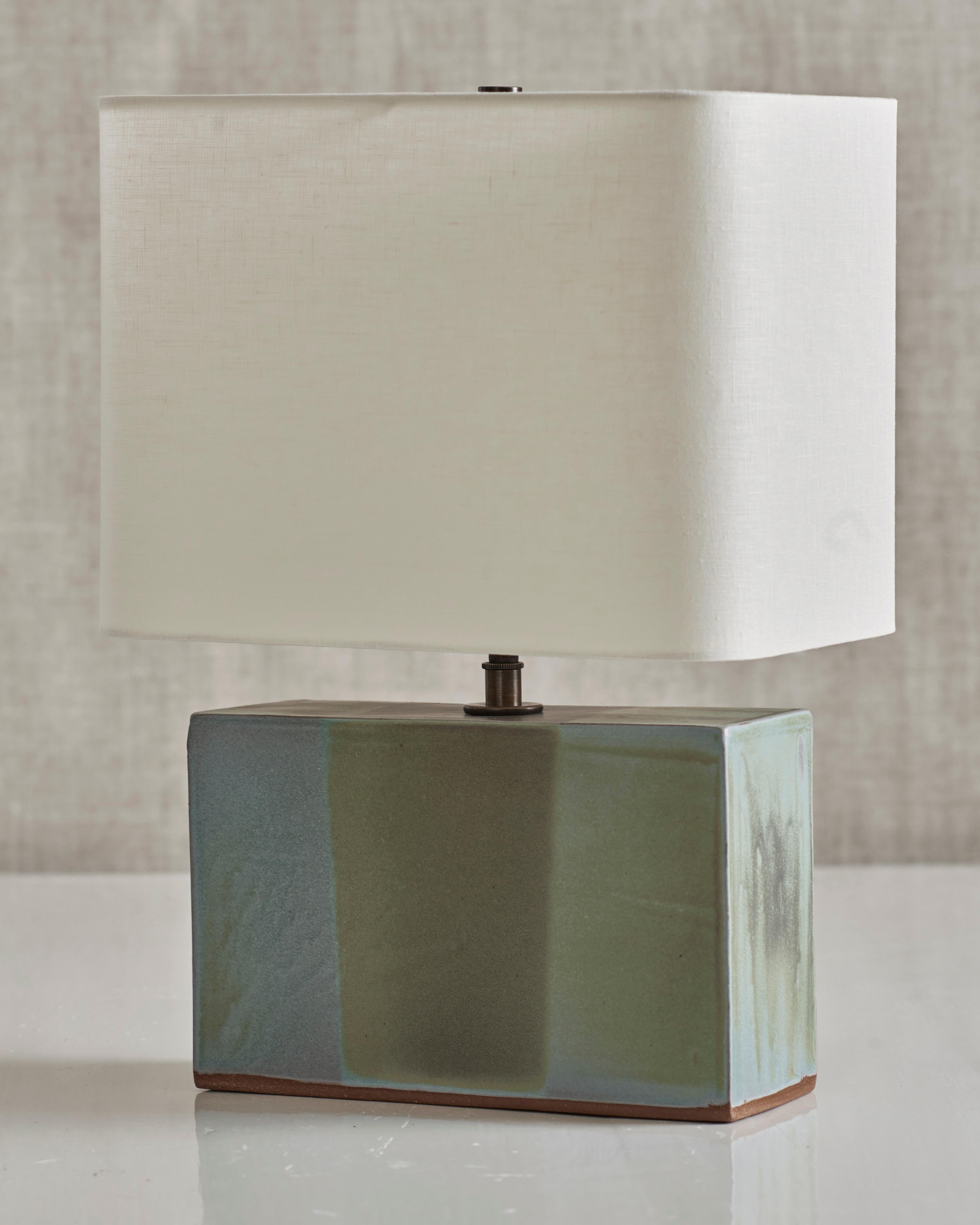 Handmade stoneware slab construction. Lamps are individually crafted and one of a kind.

Verdigris glaze. Antique brass fittings with braided black silk cord and off-white linen shade.

Measures: Box height 6.5”
Box width 10”
Box depth