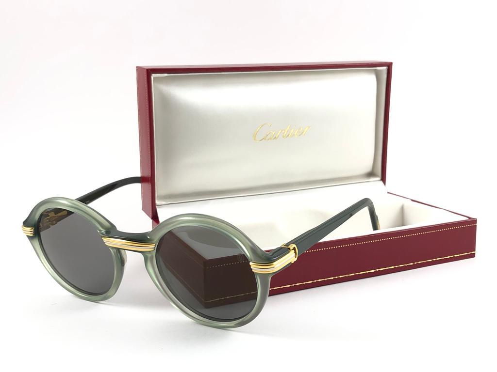 New ultra rare size 1991 Original Cartier Cabriolet Art Deco Translucent Jade sunglasses with grey slight mirrored CARTIER ( uv protection ) lenses.
Frame has the famous real gold and white gold accents in the middle and on the sides. 
All