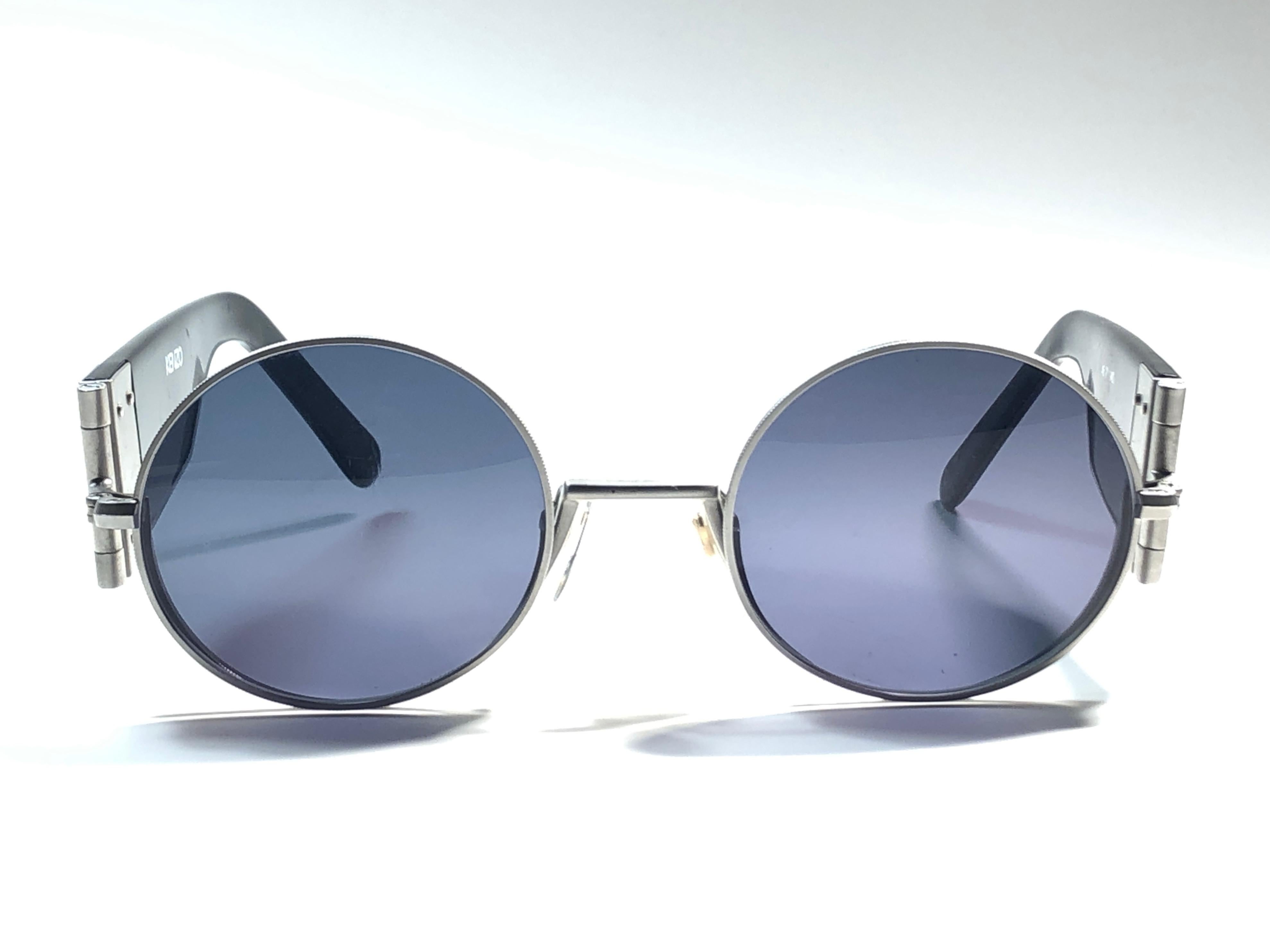New Rare Vintage Kenzo hinged foldable frame holding  pair of grey lenses.

New, never worn or displayed, this pair may show minor sign of wear due to storage. The last digits of the model had faded.

Made in France.

Front : 12 cms

Lens Width :