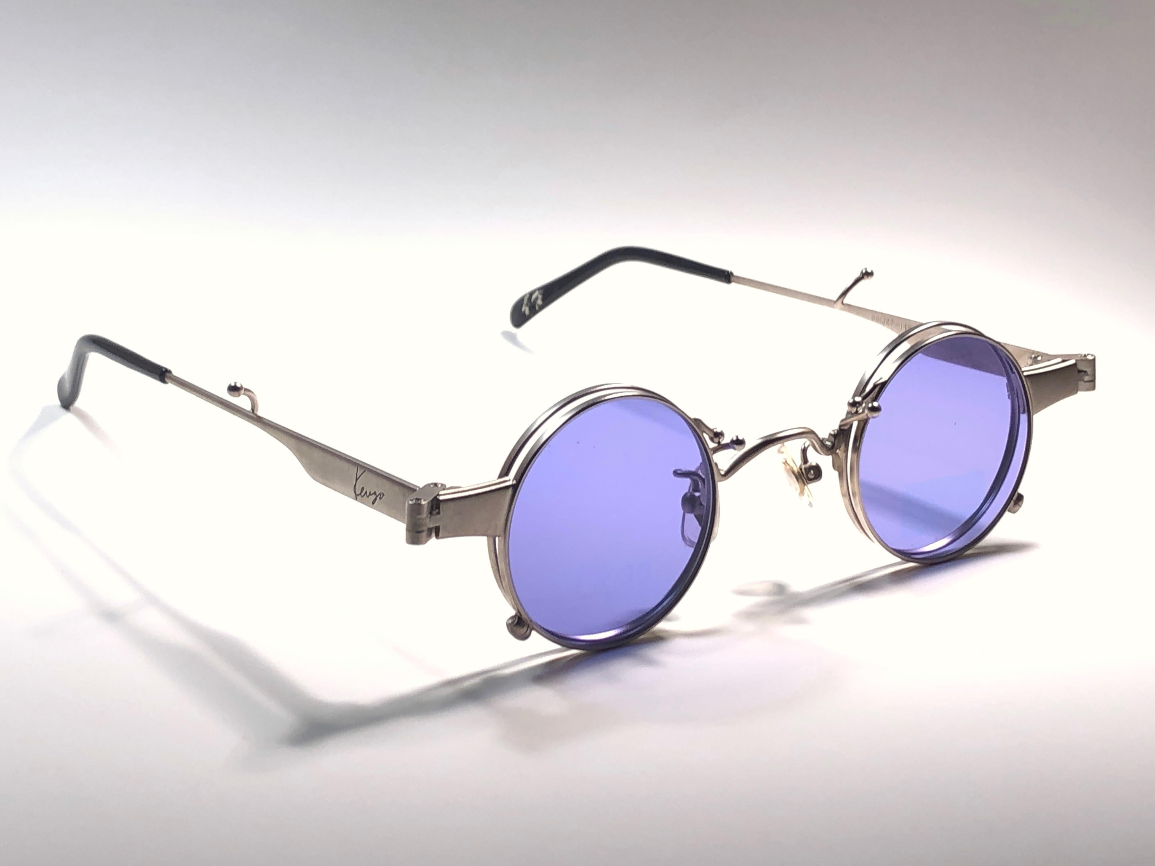 New Rare Vintage Kenzo hinged foldable frame holding  pair of grey lenses.

New, never worn or displayed, this pair may show minor sign of wear due to storage. 

Made in France.

Front : 13 cms

Lens Width : 3.5 cms

Lens Height : 3.5 cms 