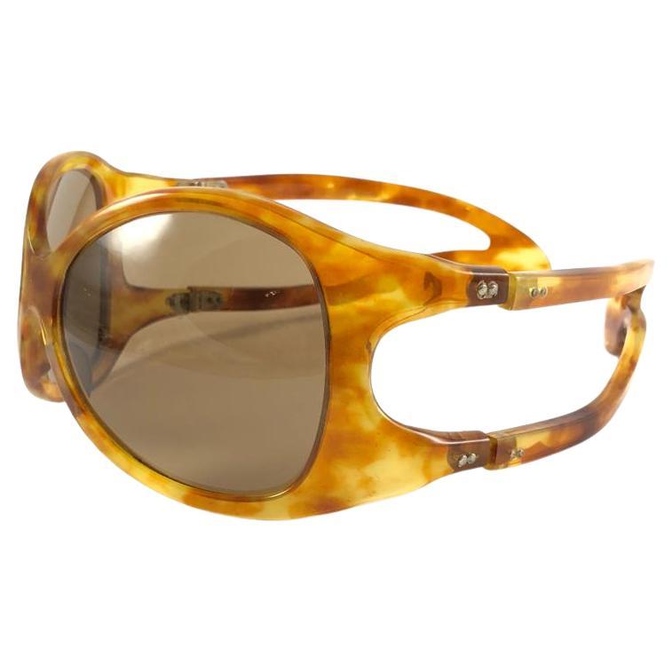ULTRA ist ein Sammlerstück, ein Museumsstück, eine übergroße Sonnenbrille in hellem Schildpatt von Philippe Chevalier mit mittelbraunen Gläsern.   
Ein großartiger Fund. 

Bitte beachten Sie, dass dieser Artikel leichte Gebrauchsspuren aufweisen
