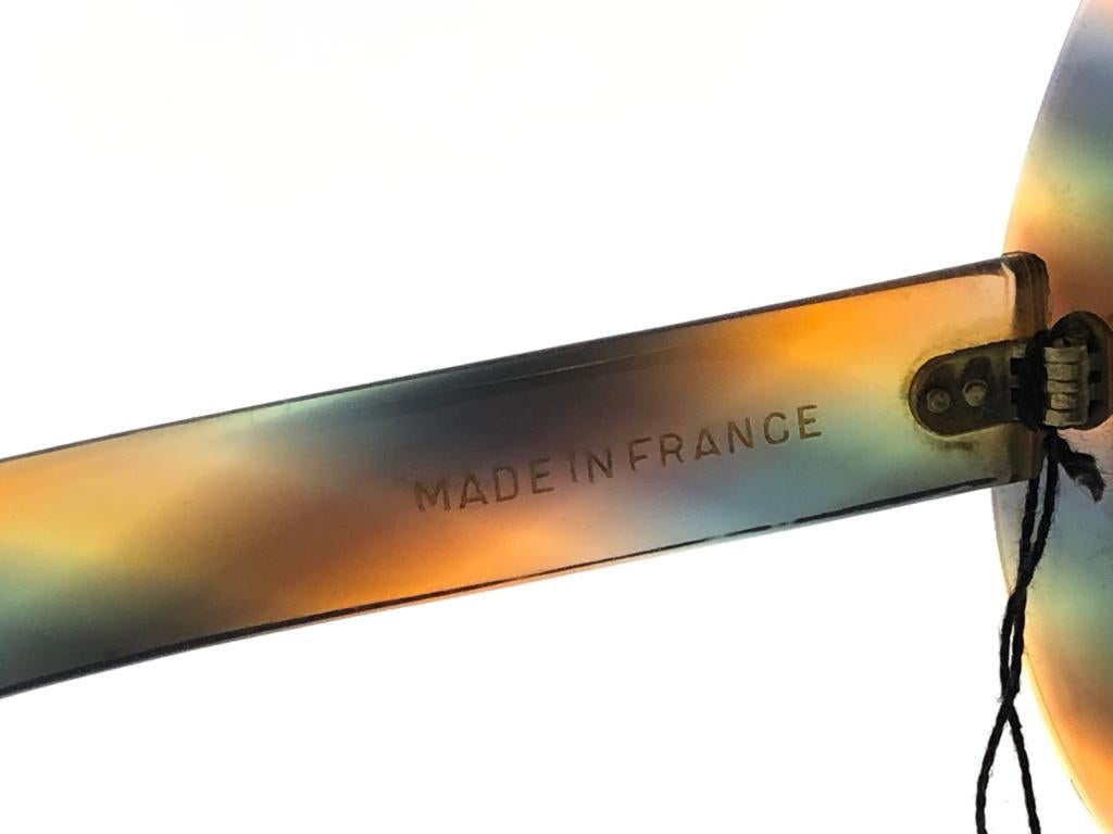 Nouvelle paire de lunettes de soleil vintage Philippe Chevalier translucide multicolore surdimensionnée, pièce de collection rare, avec mono-lentille marron moyen impeccable. De la même série que celles portées par Miles Davis.
Une superbe