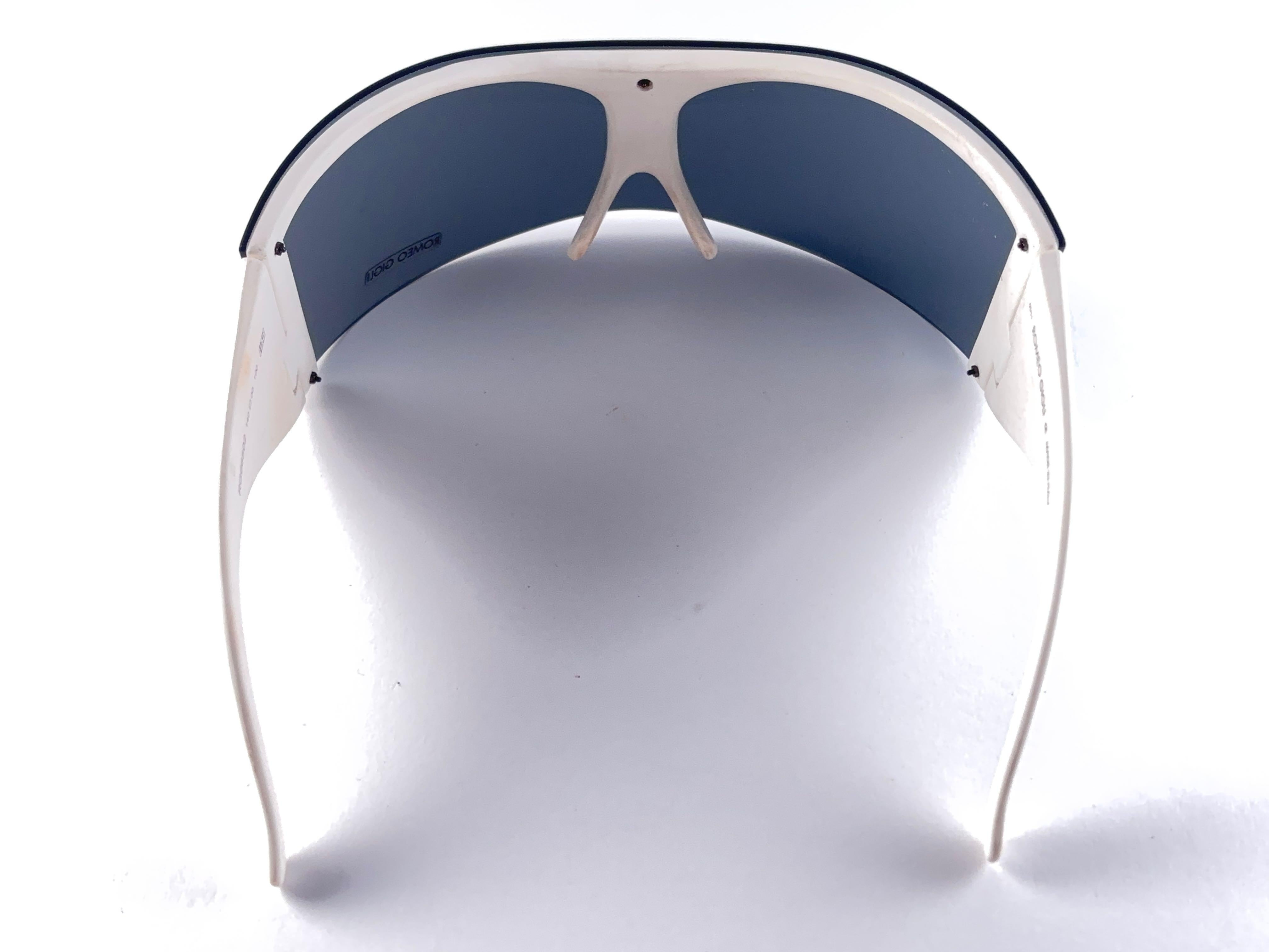 New Rare Vintage Romeo Gigli Rg66502 Mask Collector Item Sunglasses 

Produced And Design At The Beginning Of 2000'S. 

A Collector’s Piece!  

It Has Some Light Wear Due To 40 Years Of Storage.

Front : 22 Cms

Lens Height : 6 Cms

Temples : 10