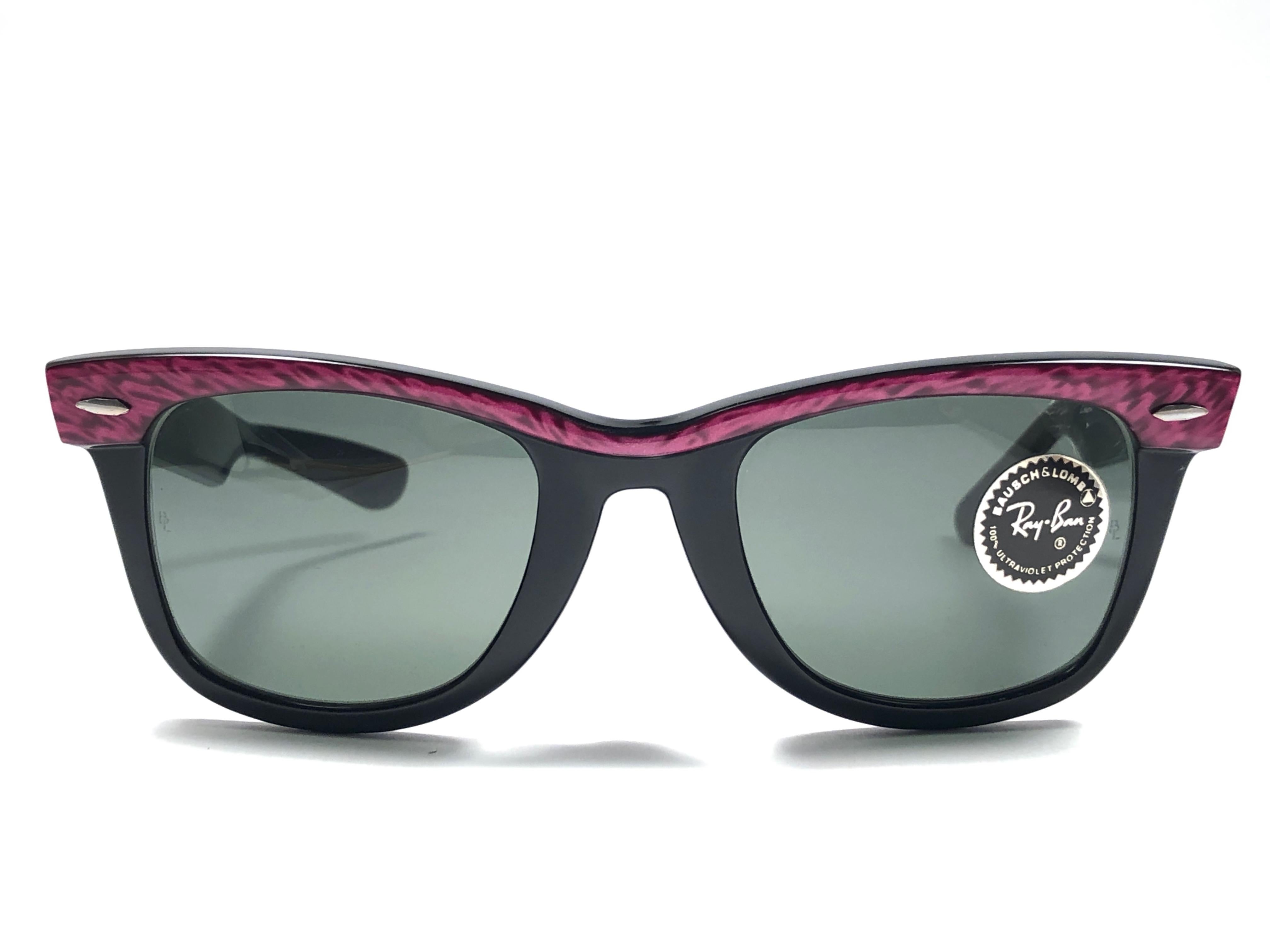 New classic Wayfarer in fuchsia & black. B&L etched in both G15 grey lenses. Please notice that this item is nearly 40 years old and could show some storage wear.  
New, ever worn or displayed.