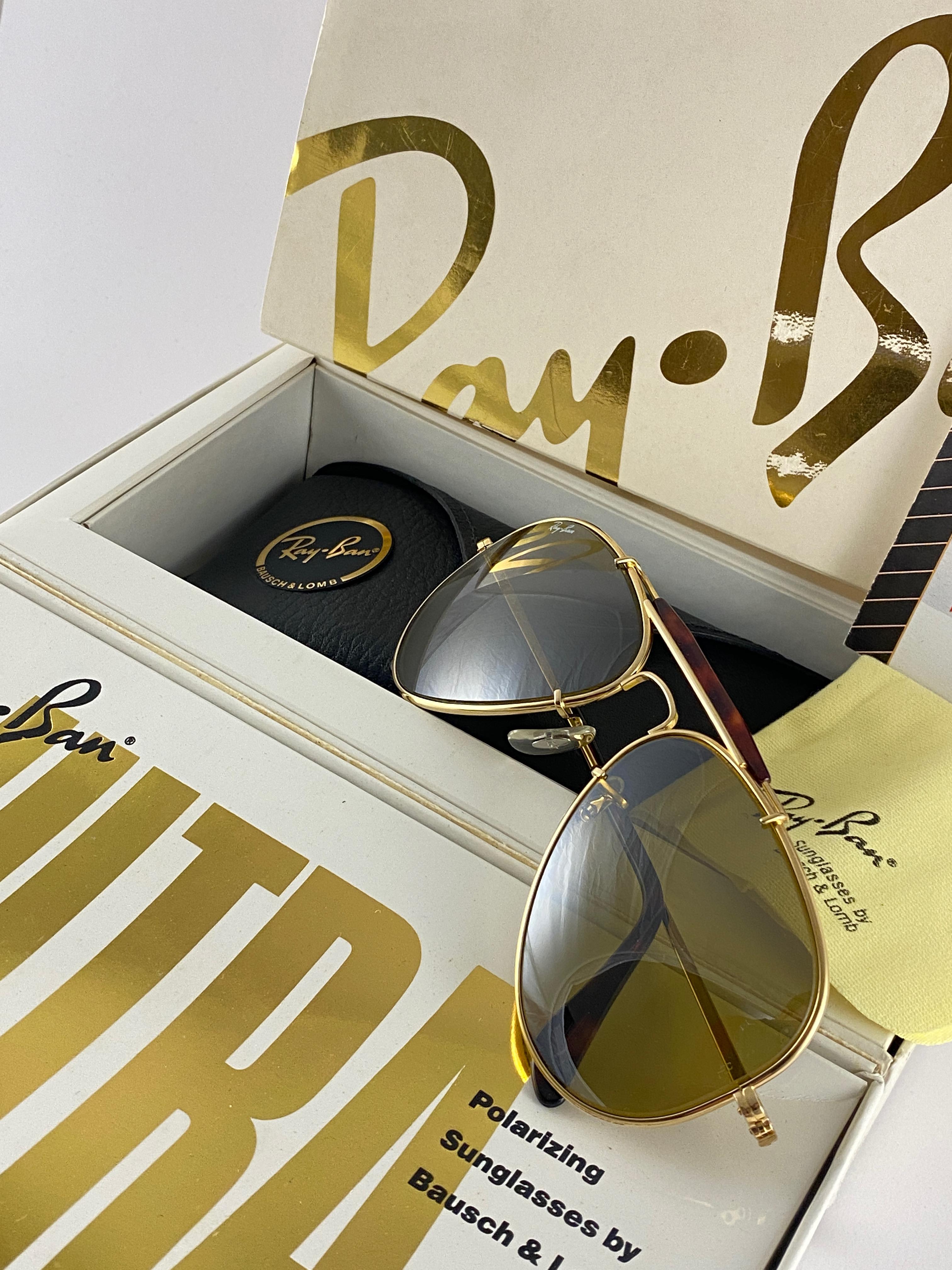 Nouvelle pièce de collection Ensemble complet Ray Ban ULTRA Deep Groove Gold Bravura frame with RB 50 mirrored lenses. 
Une paire rarement vue à la vente, surtout dans cet état neuf et non porté.

Barre de sourcils en tortue foncée sur une monture