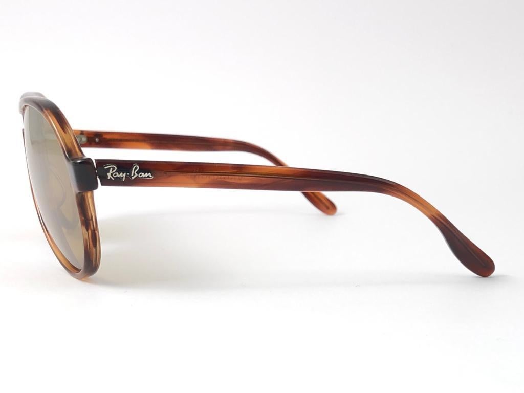 New Ray Ban Tortoise Vagabond. RB 50 mirror lenses.
Ray Ban 50 written on the right lens. B&L Ray Ban Usa. 
Designed and produced at the end of 1980's.

Classic and timeless piece. 


FRONT : 14 cms
LENS HEIGHT : 4.5 CMS
LENS WIDTH : 5 CMS
TEMPLES :