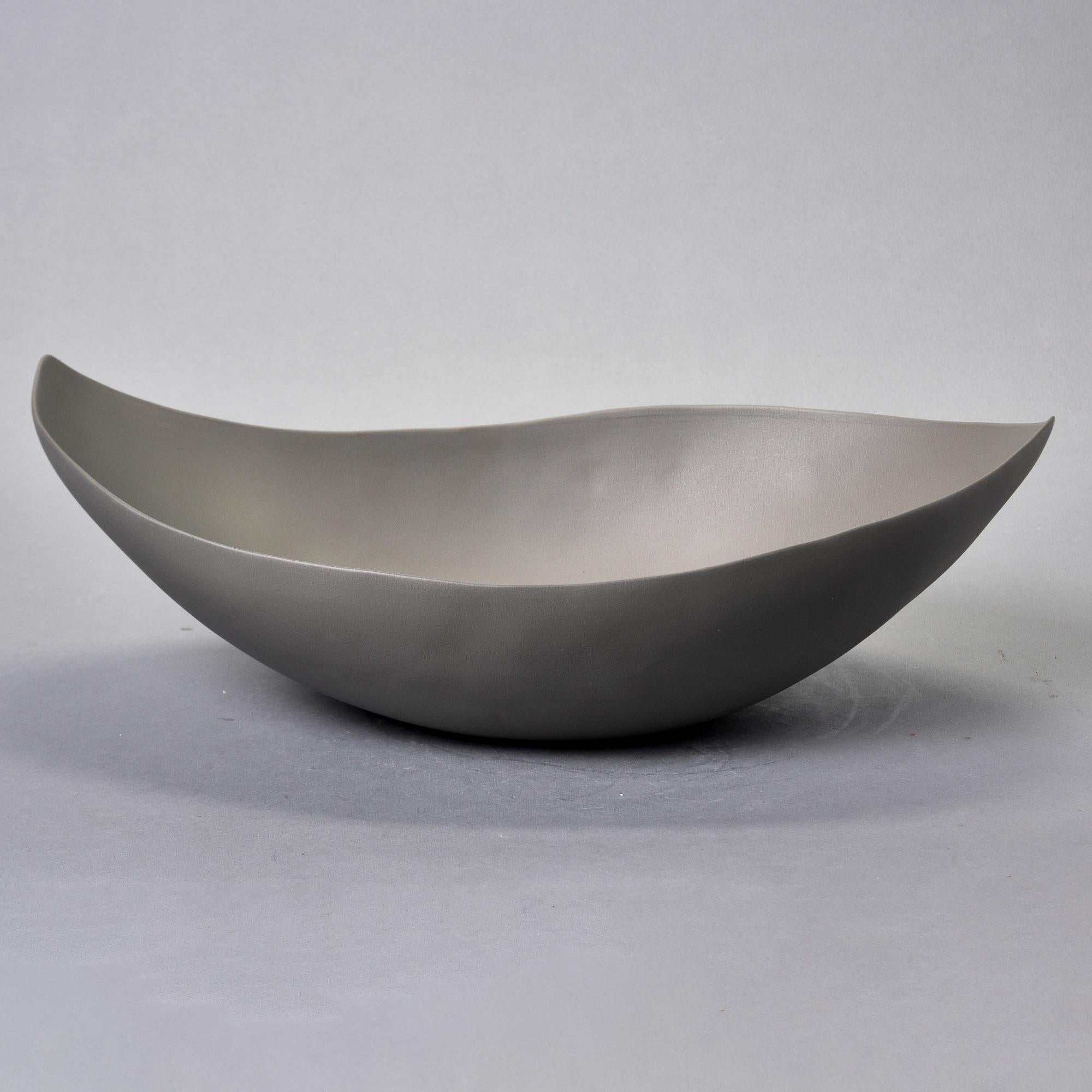 Nuova ciotola in studio Pottery di Rina Menardi. La ciotola Barchetta è una ciotola centrale poco profonda con una forma e un bordo irregolari. Forma scultorea dalle pareti sottili, smaltata in bronzo con finitura opaca di colore grigio medio. Un