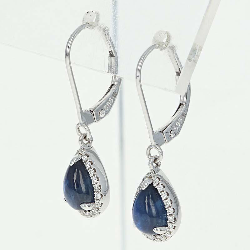 Timelessly elegant and refined, this gorgeous pair of earrings will be a breathtaking gift for your princess! These 14k white gold earrings are fashioned in a graceful drop style showcasing sumptuous sapphires framed by haloes of glittering