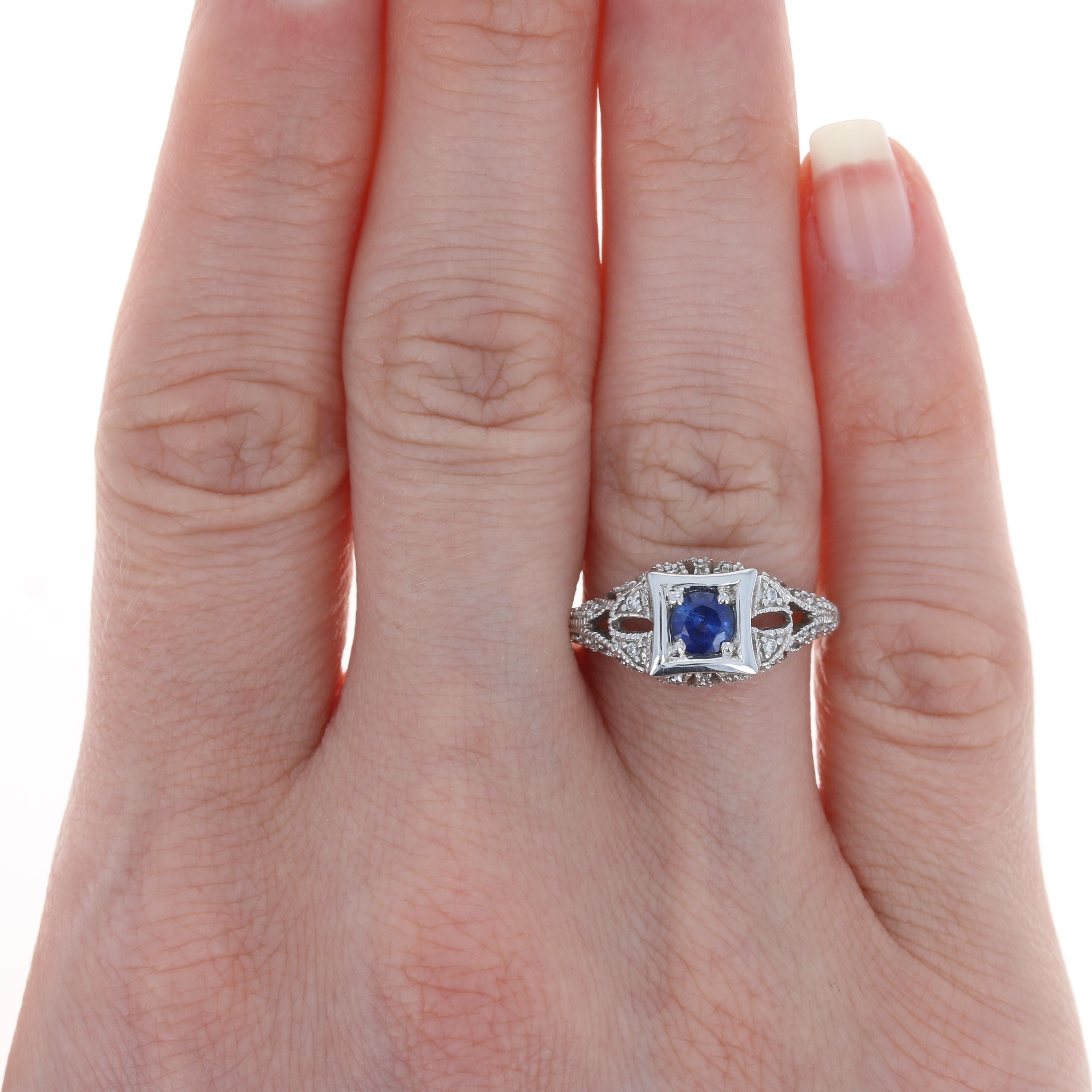 The essence of elegance, this ring is the perfect gift for someone celebrating a special birthday or milestone anniversary. This gorgeous NEW piece is fashioned in high purity 18k white gold and features a navy-blue sapphire in a polished bezel