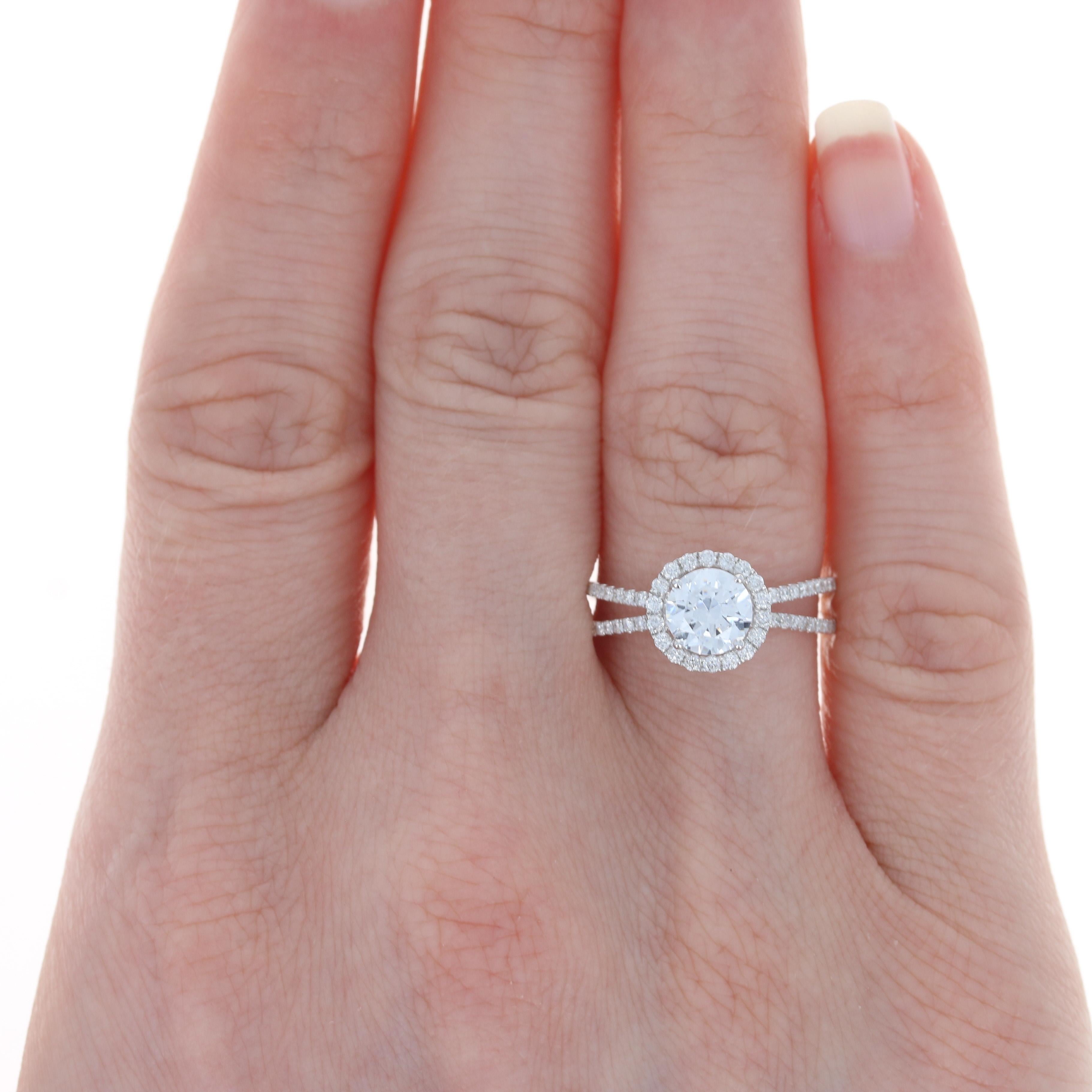 Composed of 18k white gold, this breathtaking NEW semi-mount engagement ring showcases a cubic zirconia set as a placeholder for the 6mm - 6.5mm diamond or gemstone solitaire of your choosing. The solitaire is elegantly encircled by a sparkling