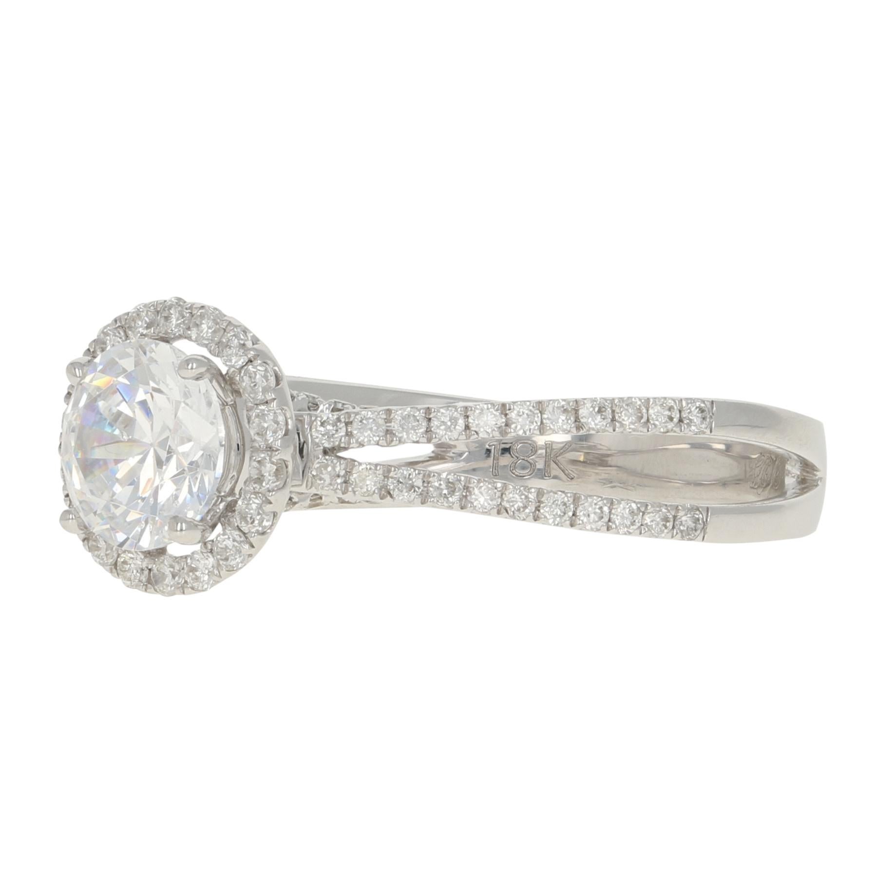 Composed of 18k white gold, this breathtaking NEW semi-mount engagement ring showcases a cubic zirconia set as a placeholder for the 6mm - 6.5mm diamond or gemstone solitaire of your choosing. The solitaire is elegantly encircled by a sparkling